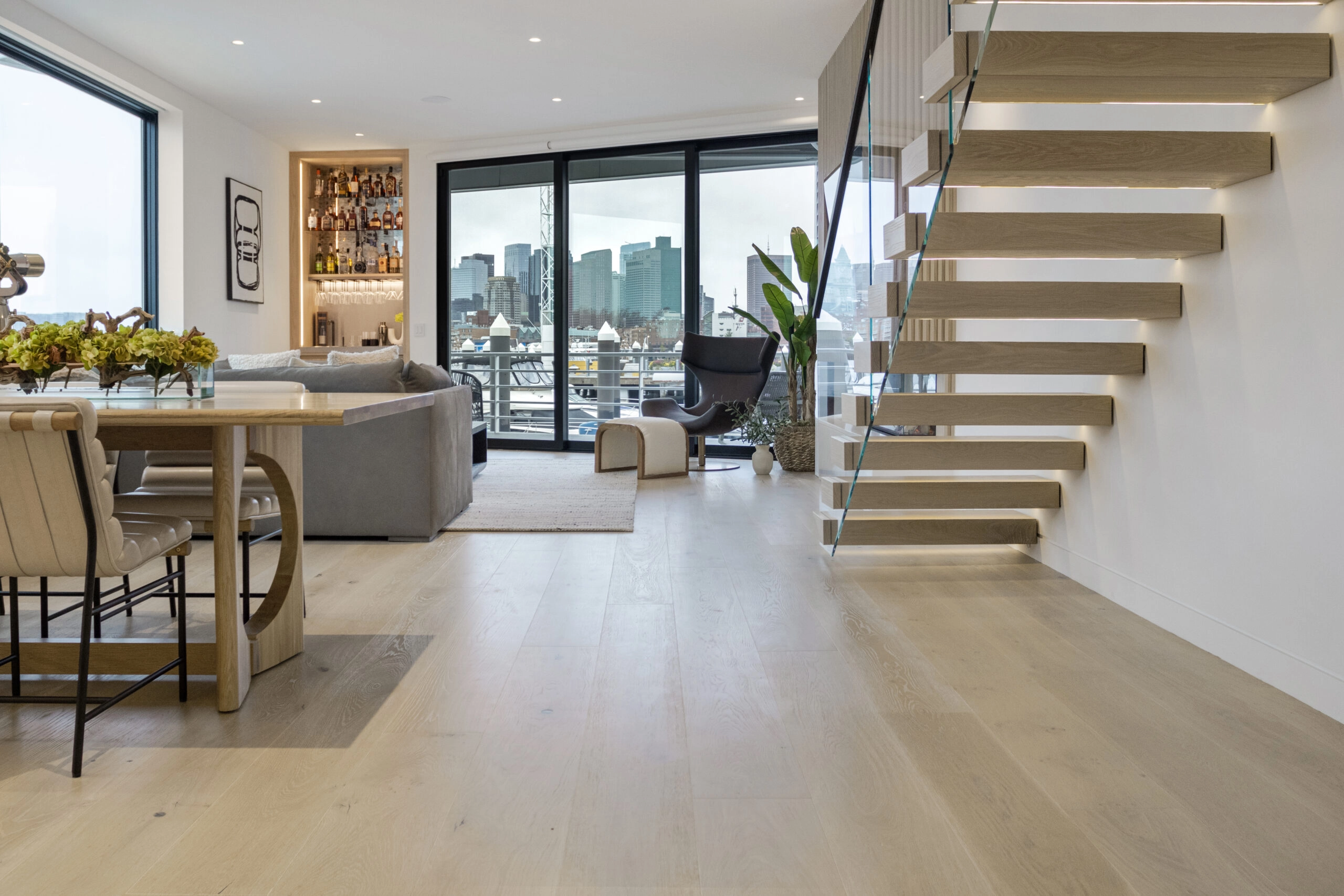FLIGHT Cantilever treads float from a condo wall above a harbor-view living room