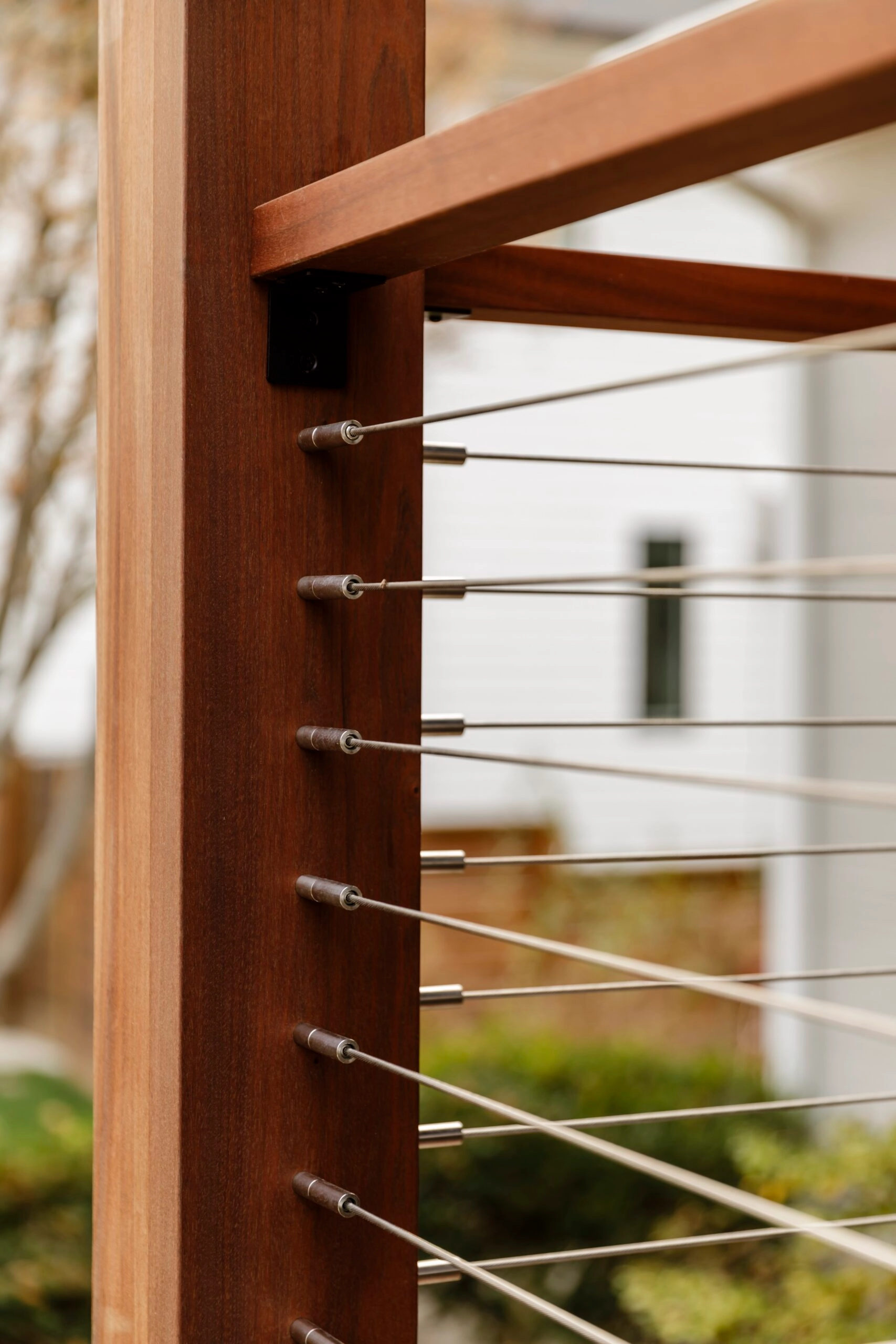 DriveTite cable railing on a covered porch, lines anchored into a wood post