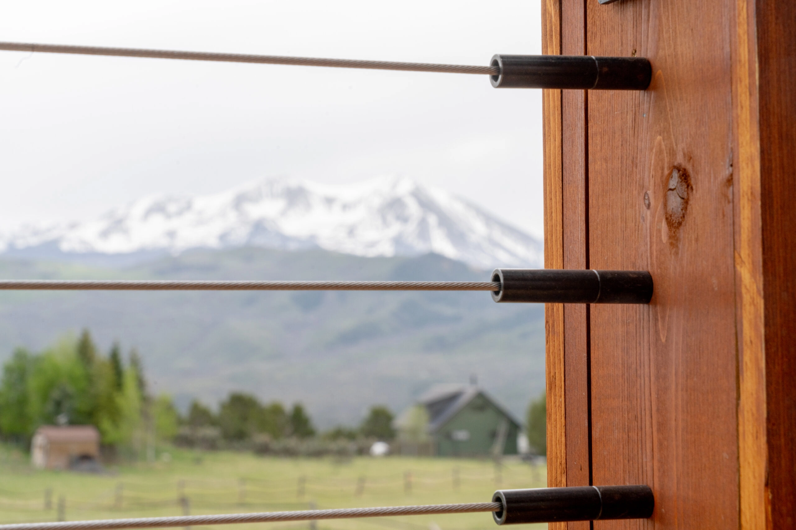DriveTite fittings seat cable lines into a wood post above a mountain valley