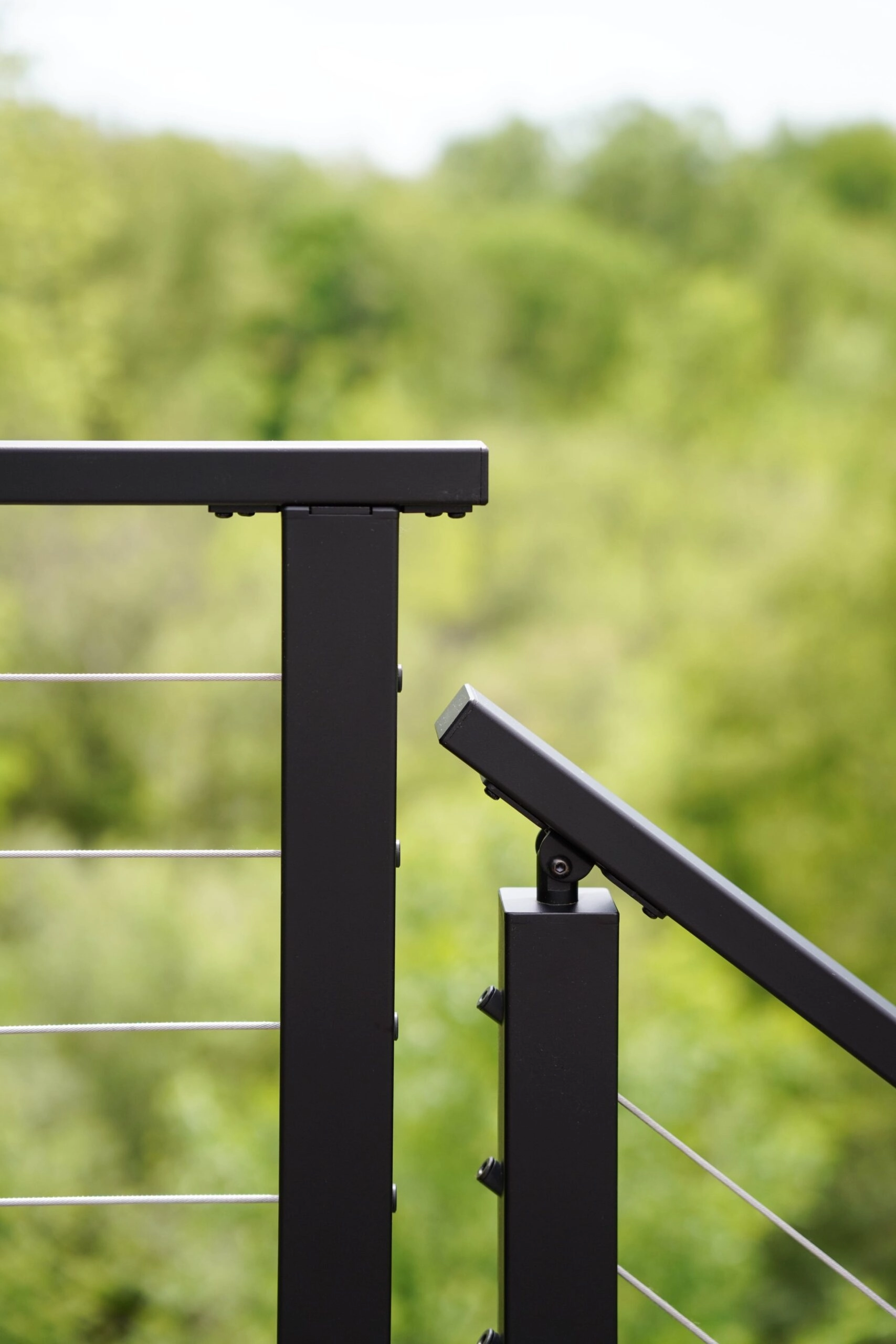 Close-up where a level cable run meets an angled one at a black corner post