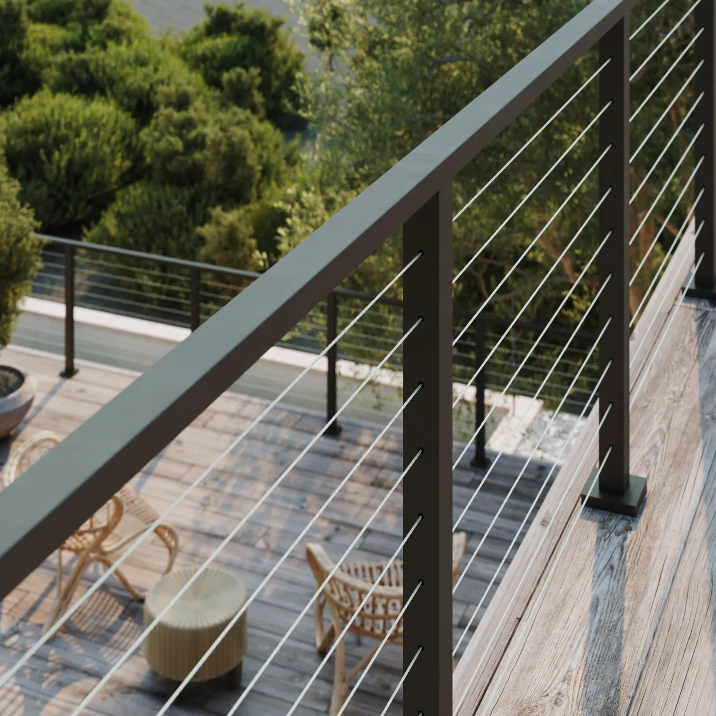 Black-capped cable railing wraps a hillside deck with woven lounge chairs