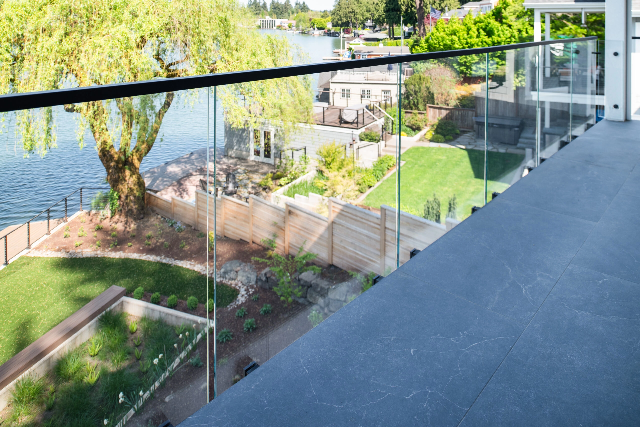 Ascend Talons spigots hold frameless glass along a lakeside terrace