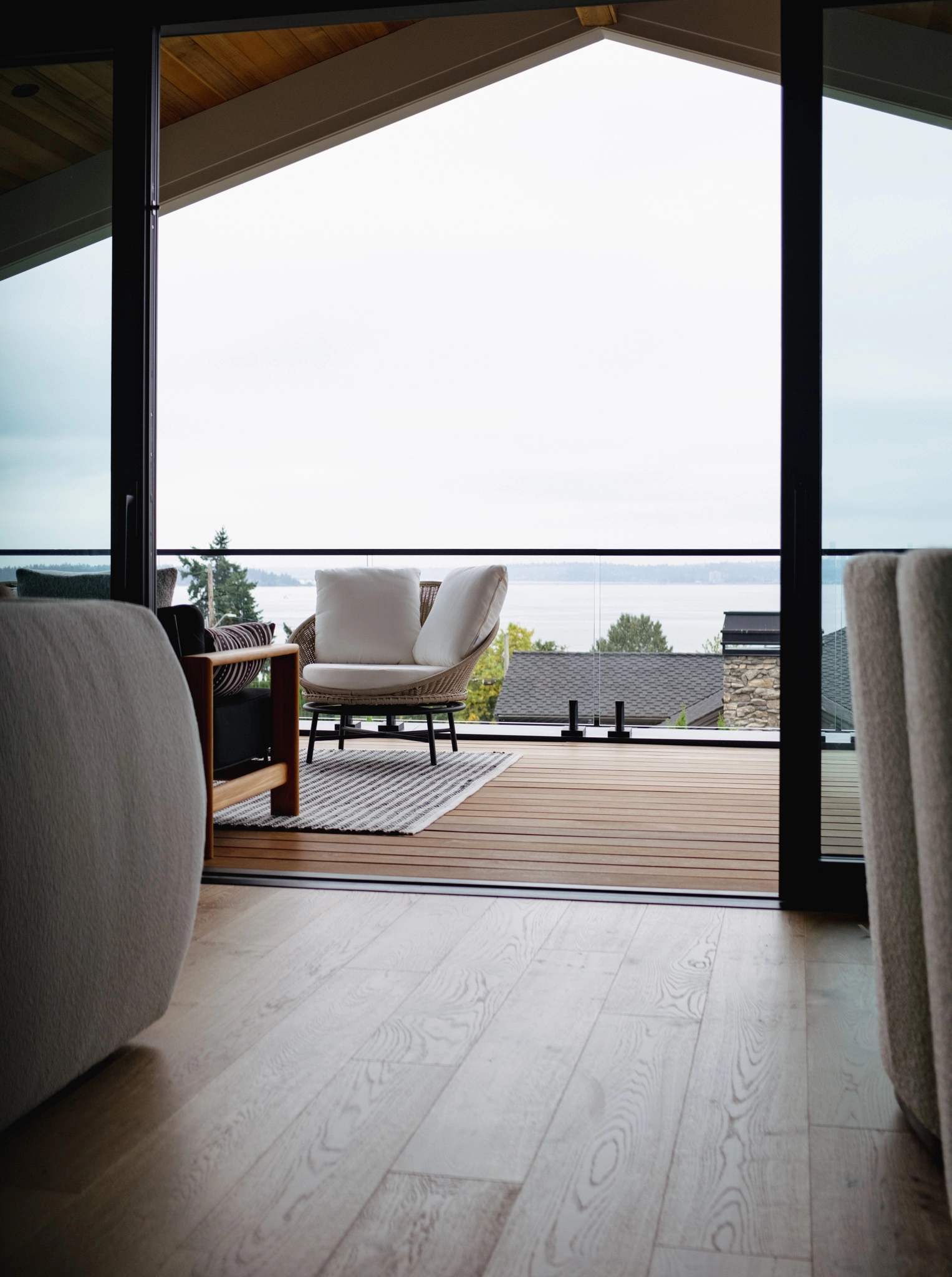 Seen from indoors, a glass railing keeps a deck's water view unobstructed