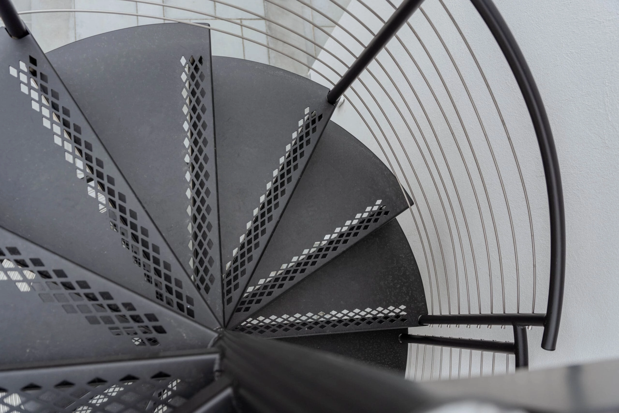 Overhead view of a black spiral stair with perforated metal treads