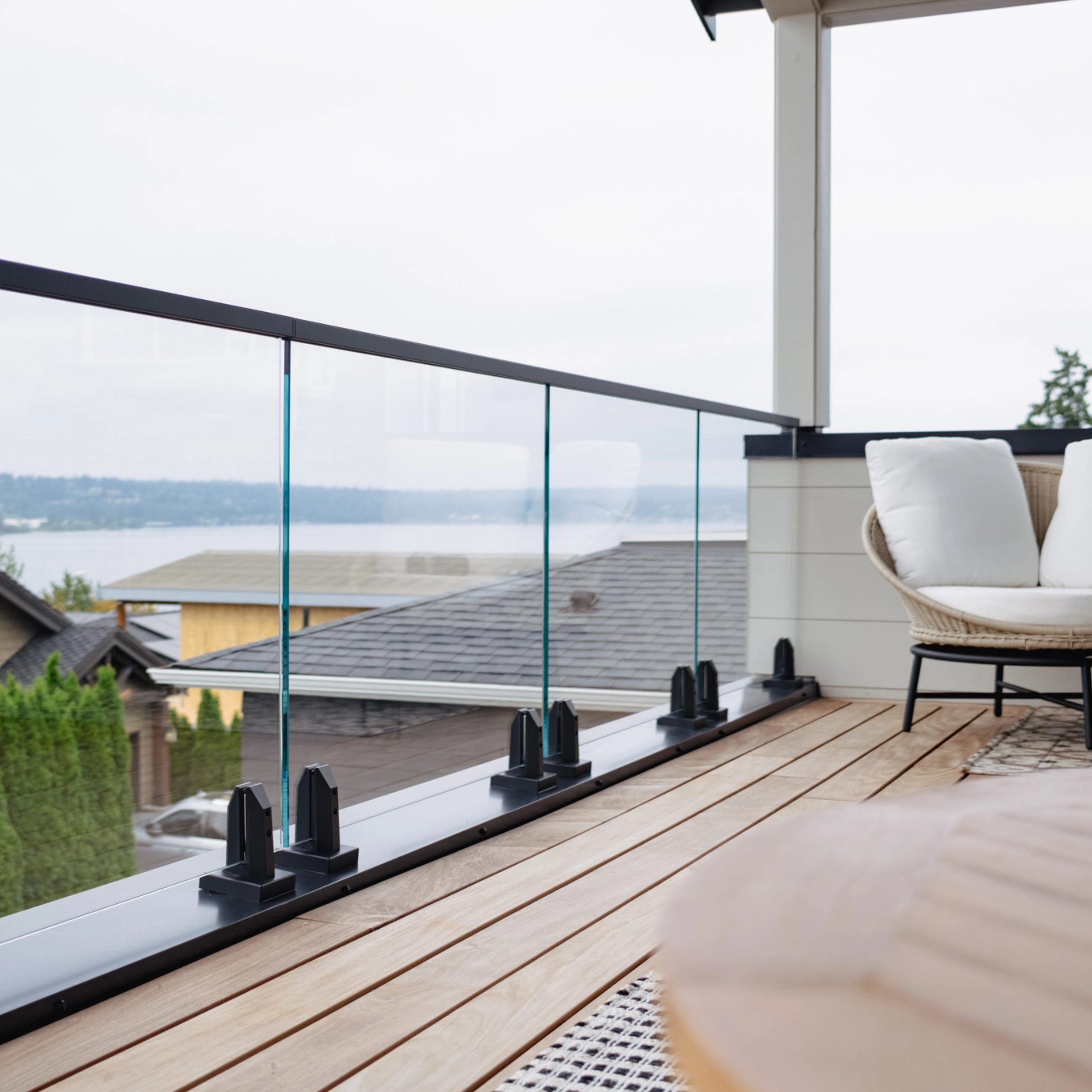 Glass panels rise from black spigots along a deck above a bay