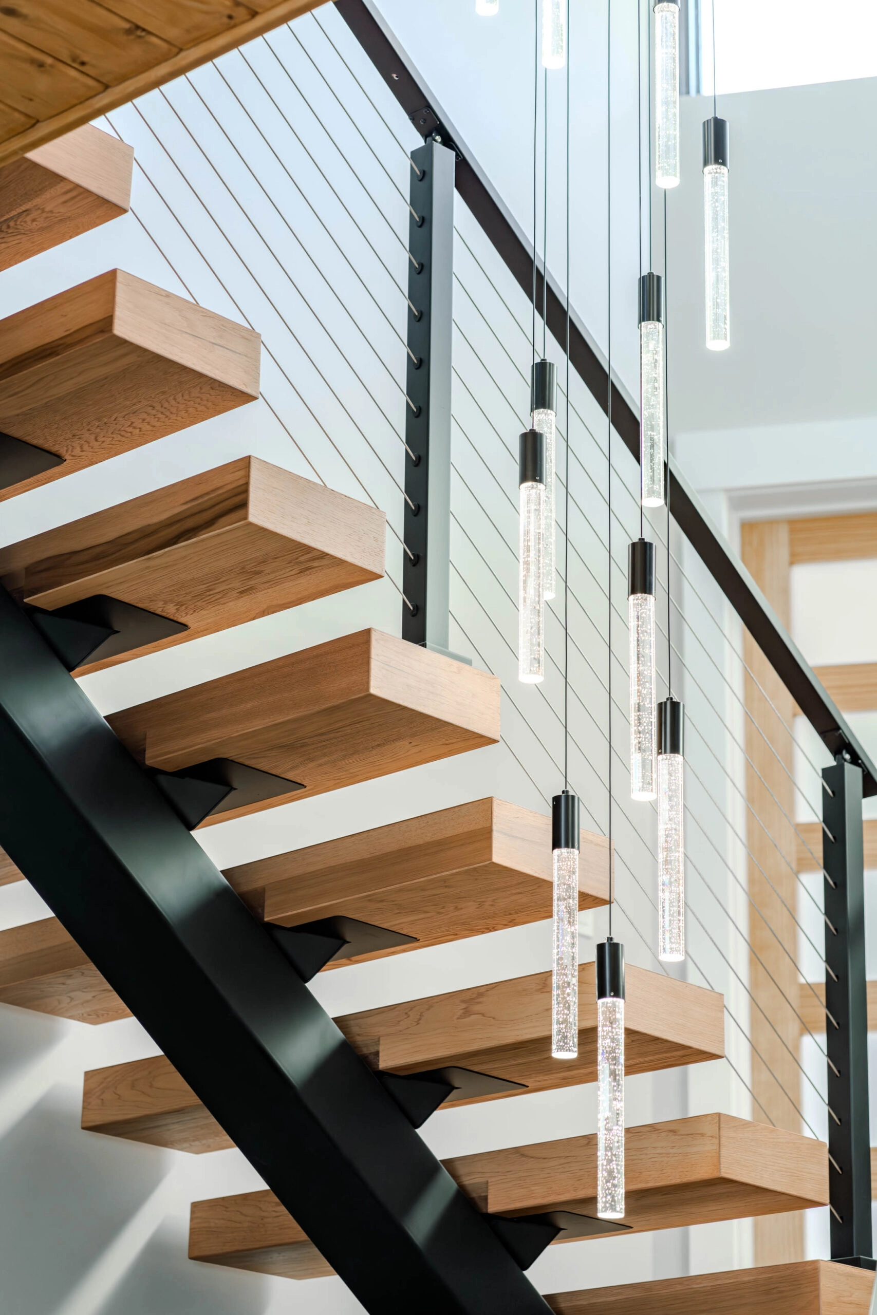 Open risers seen from below with cylindrical pendants hanging alongside the cable railing