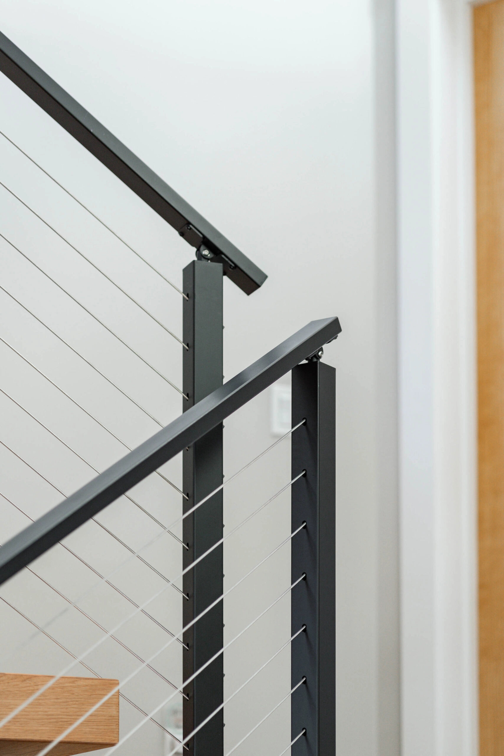 Two railing sections meeting at a corner post next to a wood door frame