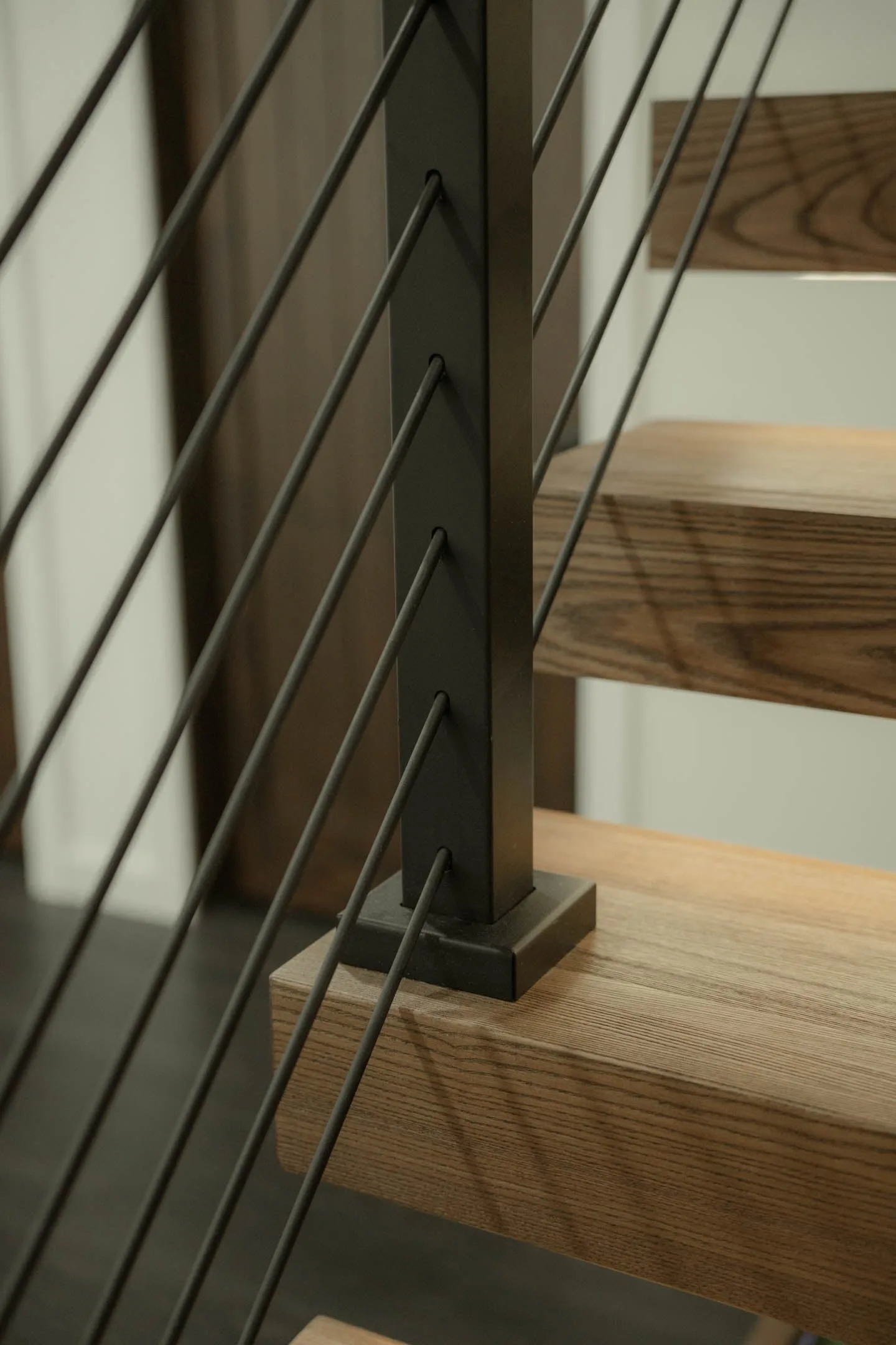 Rod railing post landing on a wood tread with black base plate