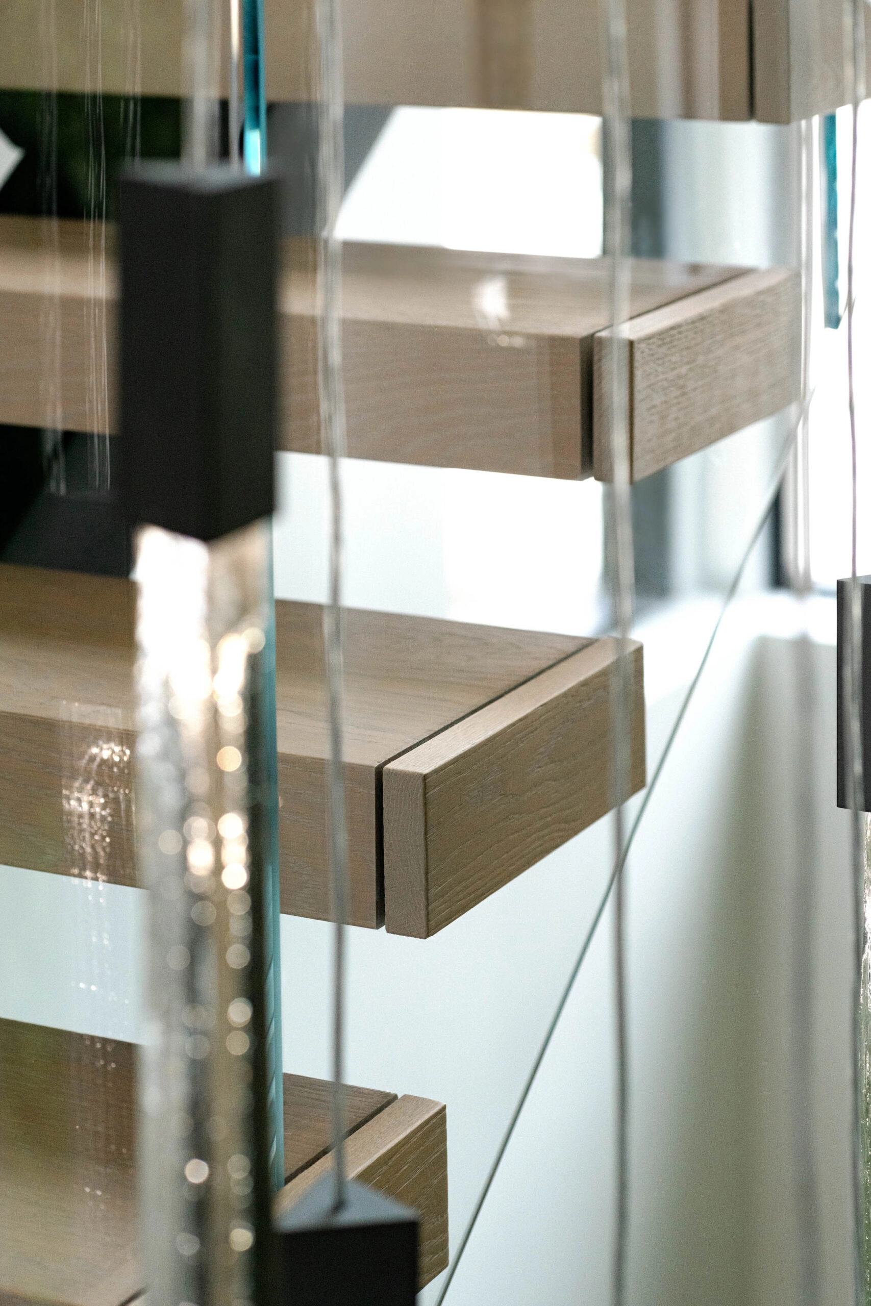 Detail of tread ends behind glass with pendant cords falling past
