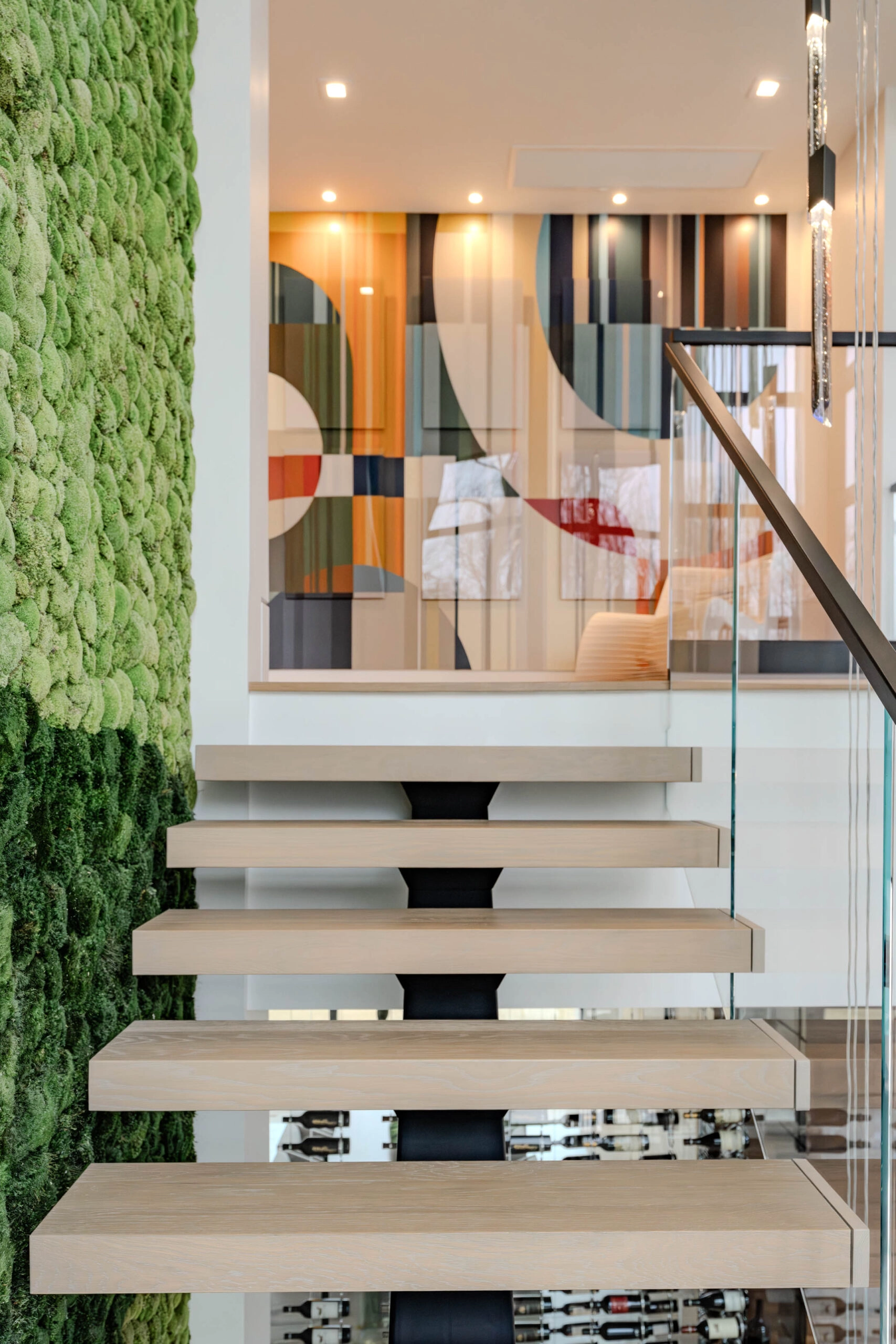 Head-on view of treads cantilevered from a black center stringer below framed art