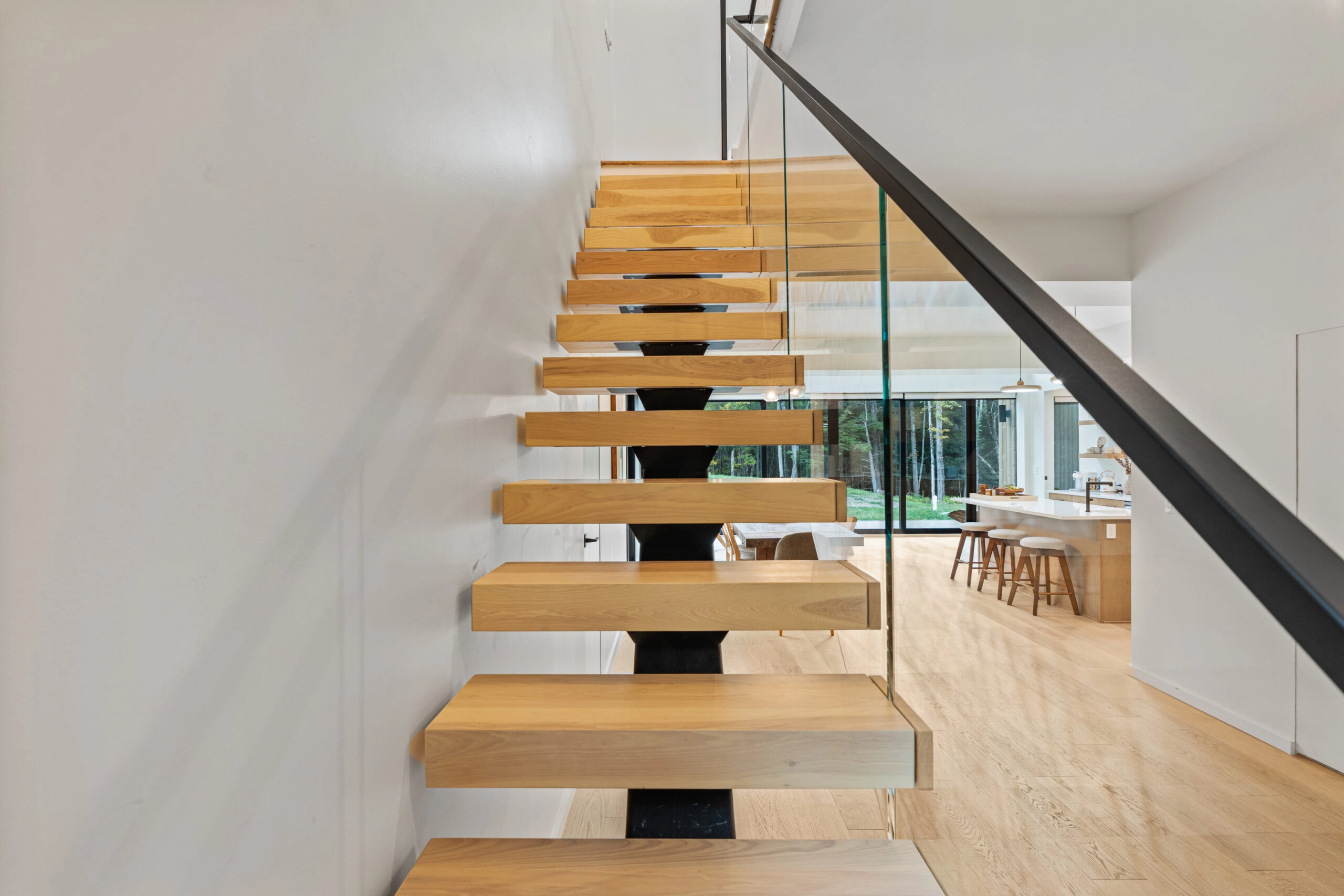 Straight view up the flight of wood treads on a black center stringer