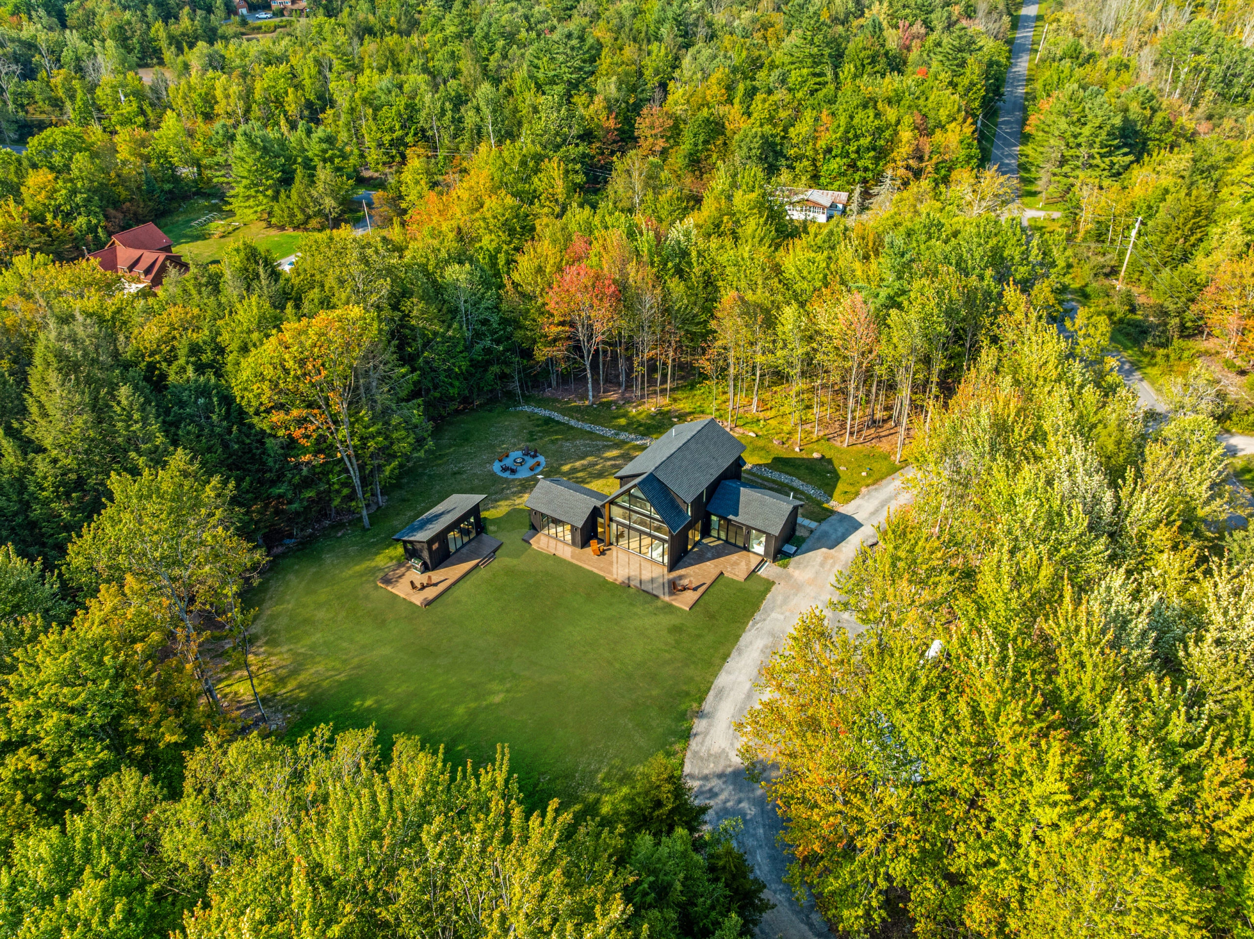 Aerial view of the house and clearing surrounded by fall woods