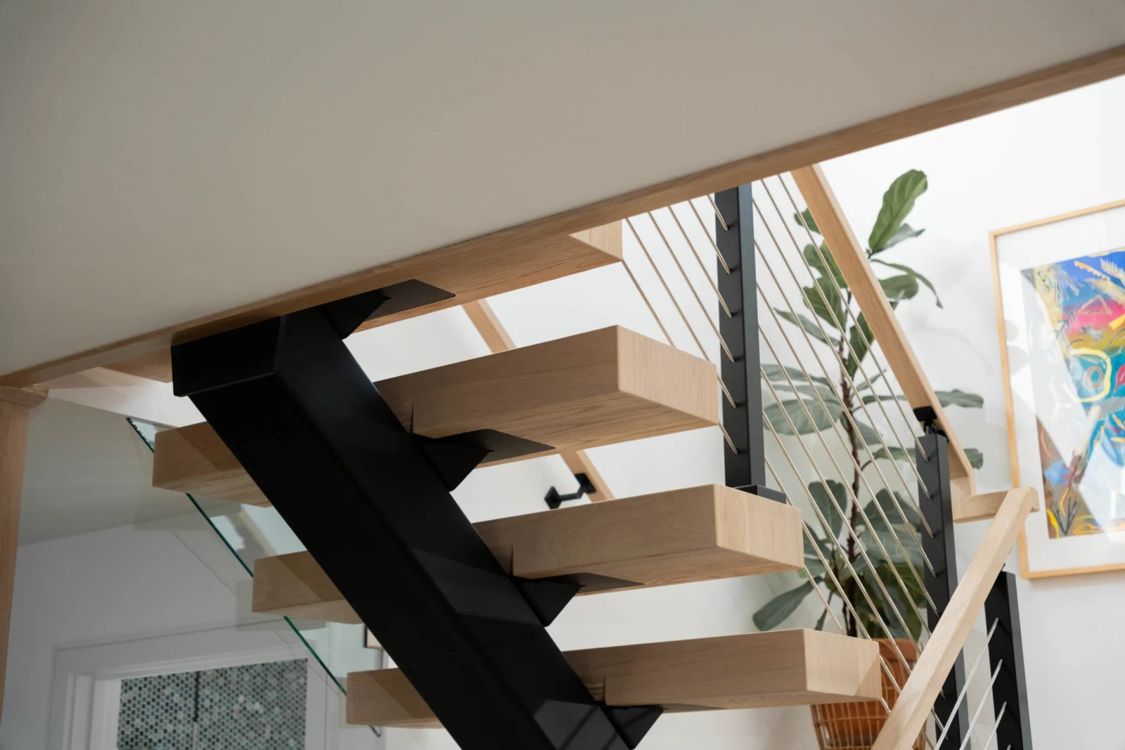Looking up at the black center stringer carrying cantilevered wood treads