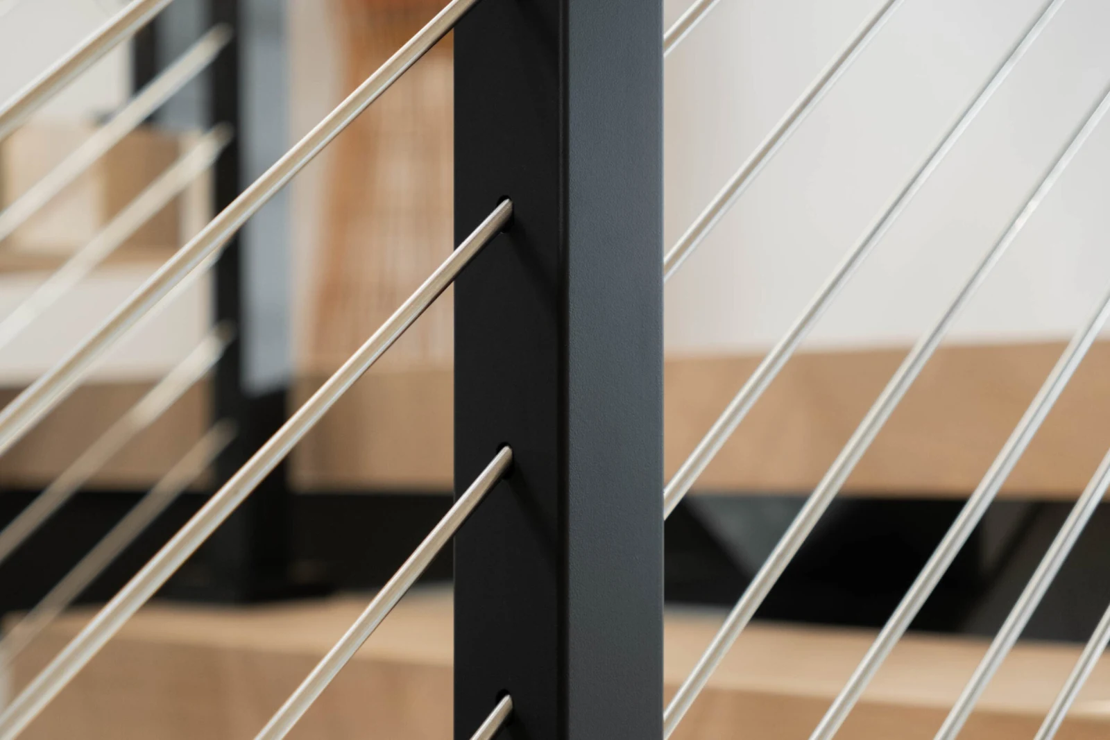 Tight abstract frame of stainless rods crossing a black post