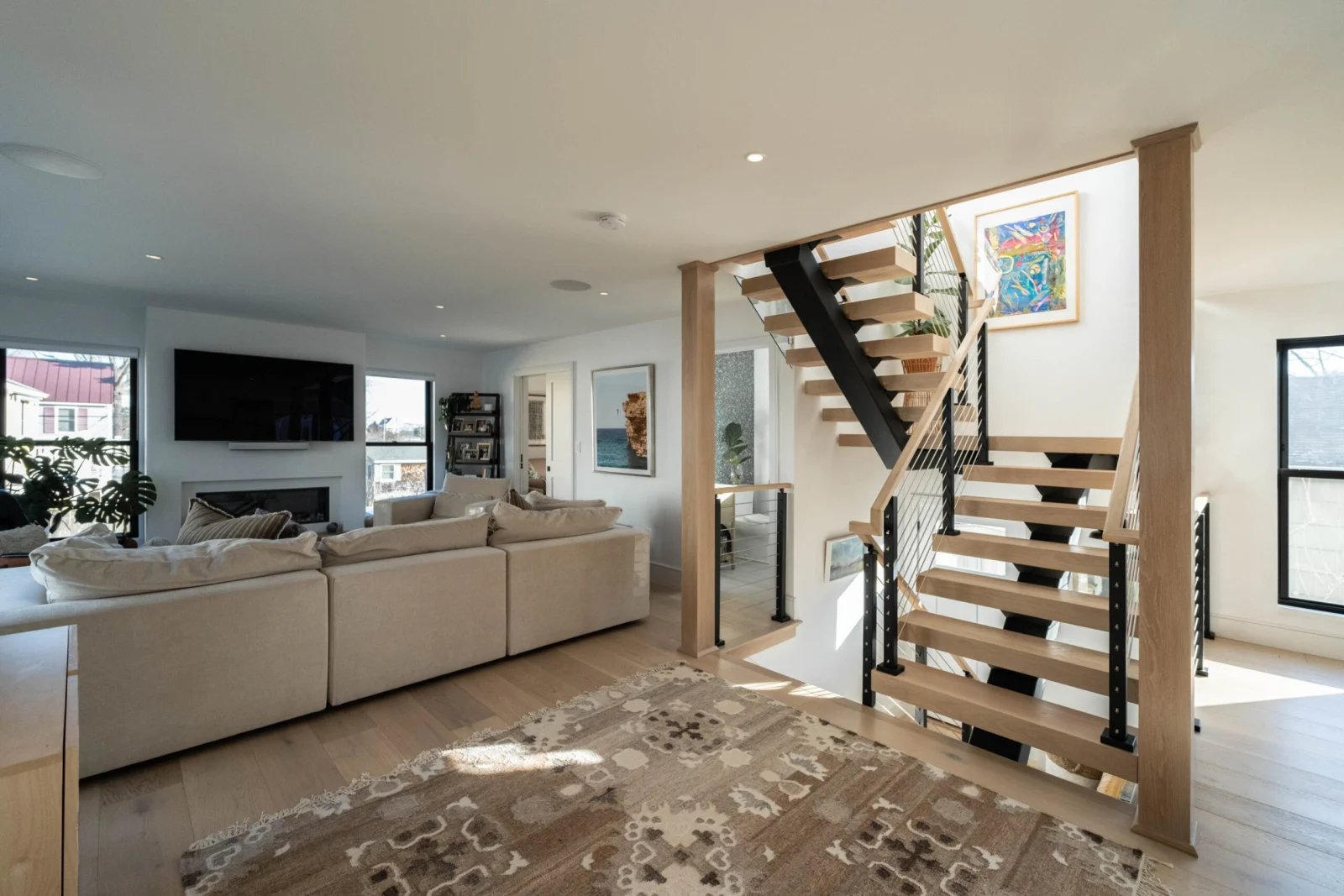 Living room with sofa and fireplace and the stair rising at right