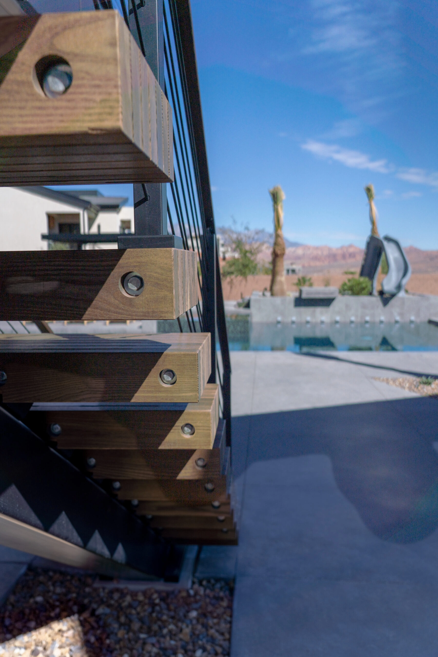 Close angle on outdoor tread ends with a pool and desert ridgeline beyond