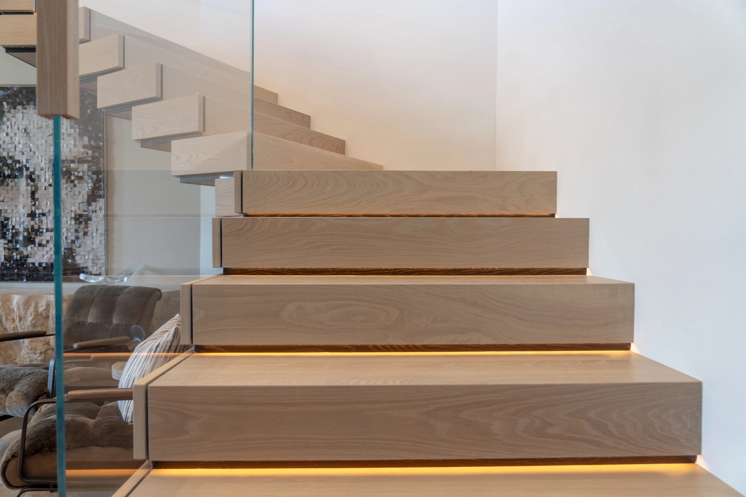 Wide bottom treads with warm light glowing from beneath each stacked step
