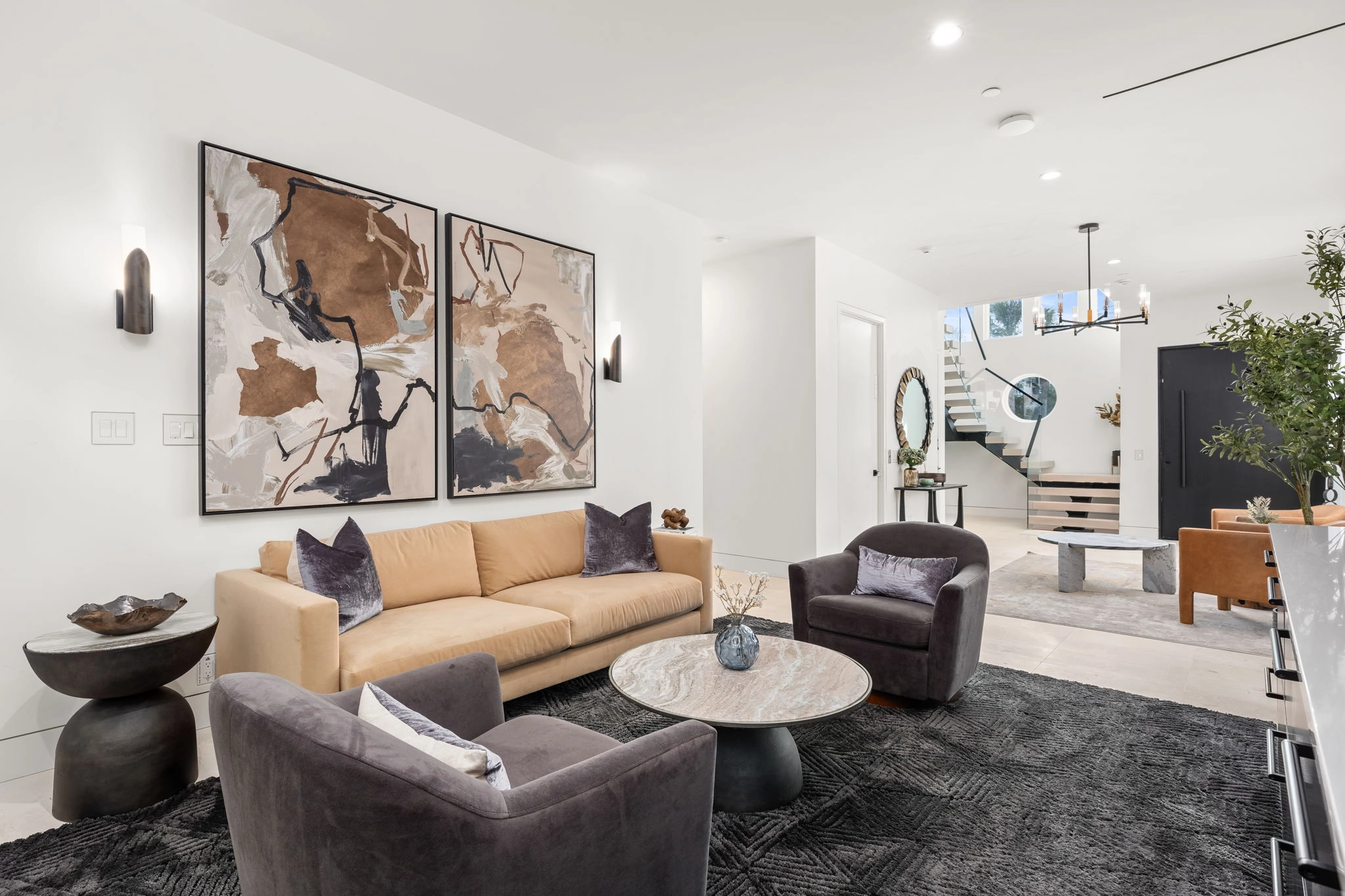 Sitting room with paired artwork and the stair landing visible through the far doorway