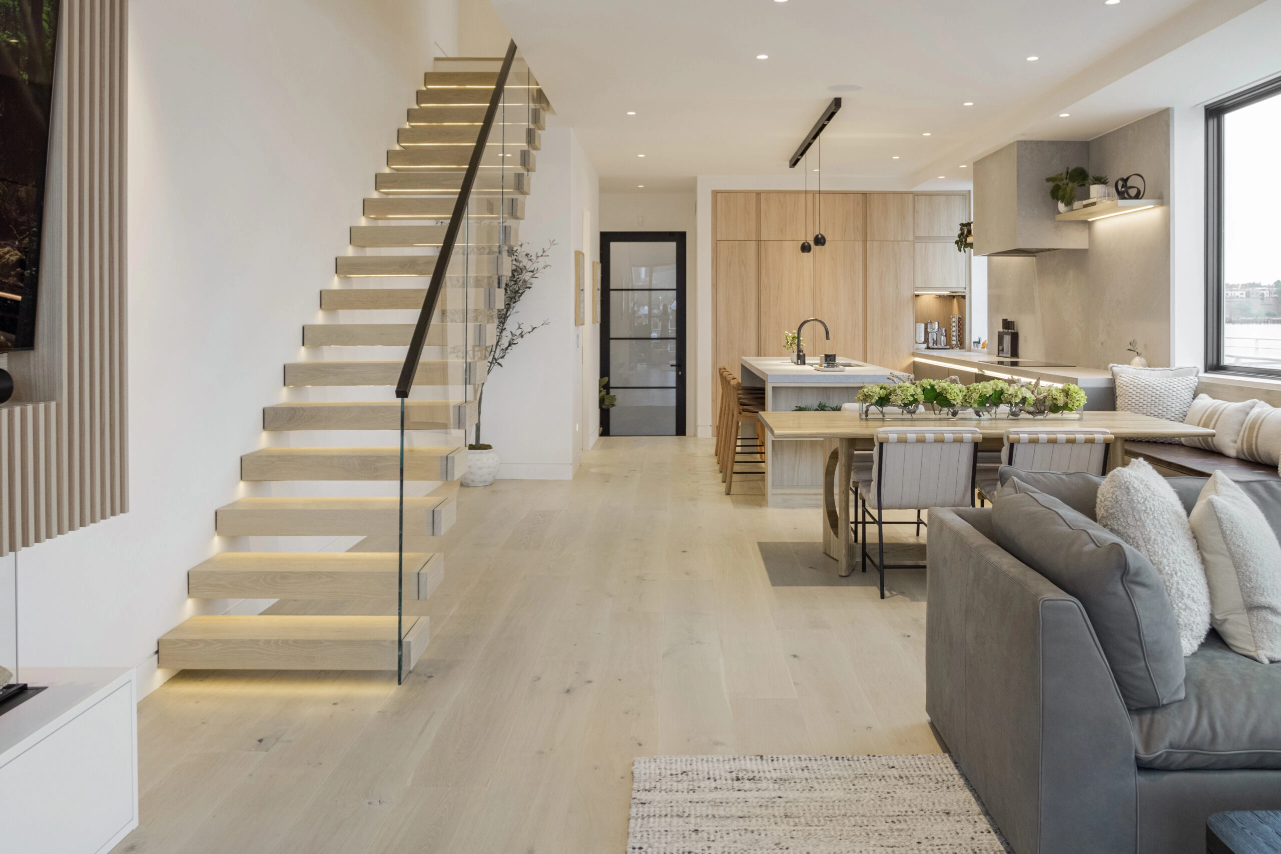 Open kitchen and seating area with the stair climbing the wall on the left
