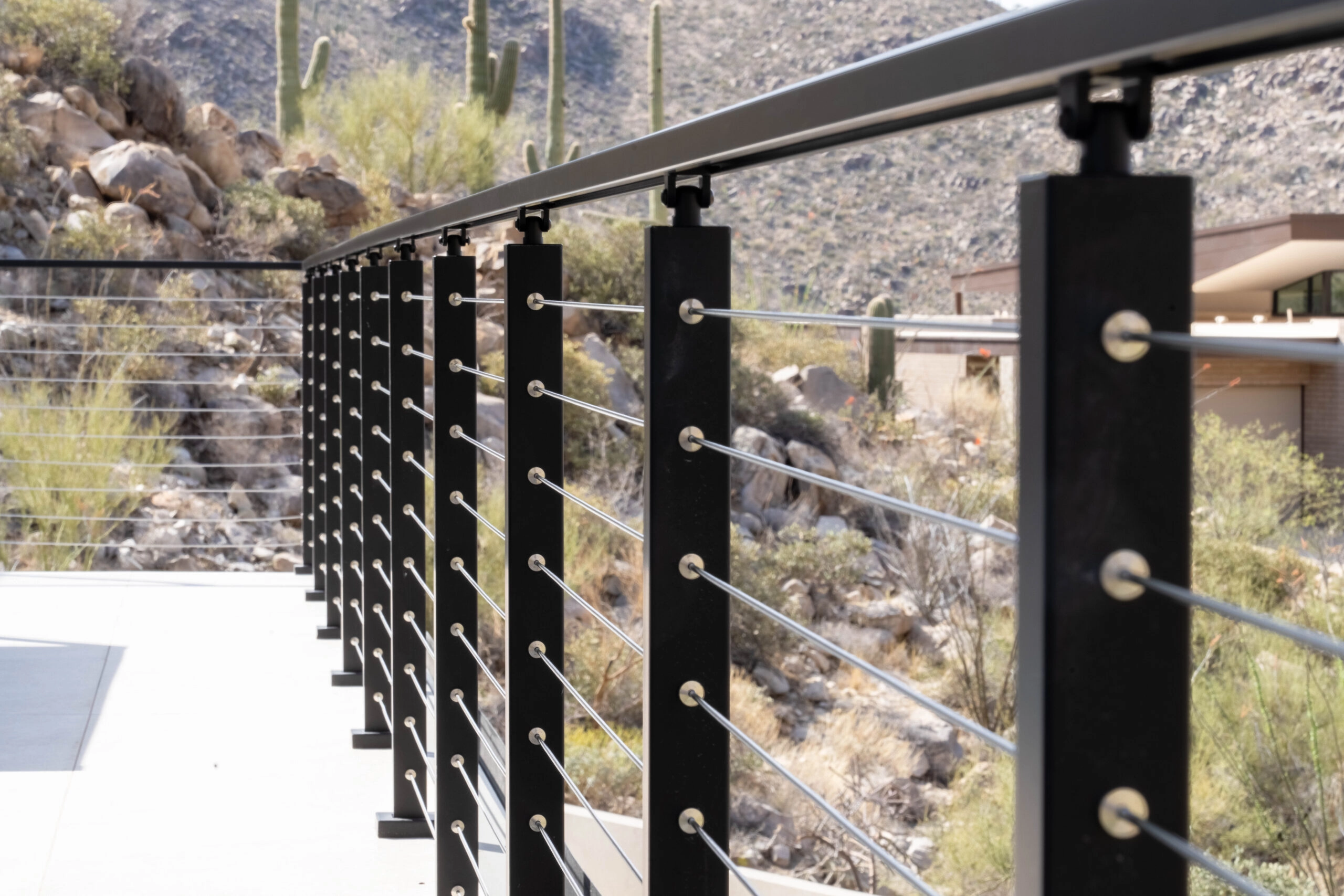 Cable railing running along a terrace with a rocky mountain slope behind