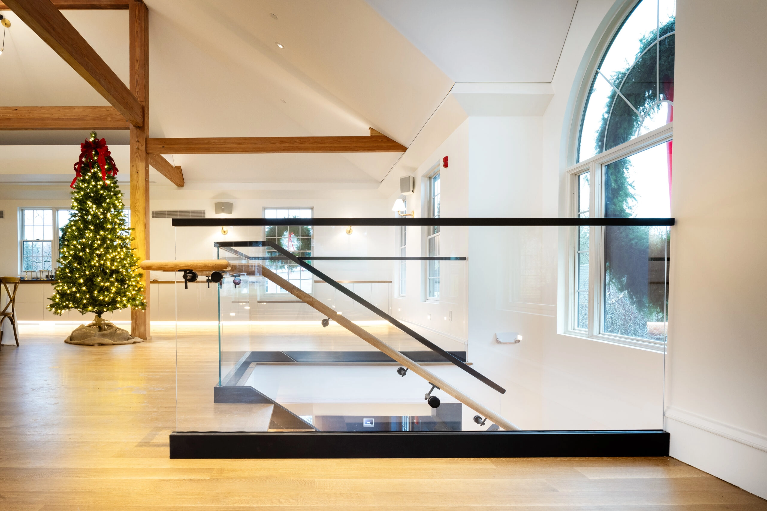 Glass panels ringing a stair opening in a beamed event room
