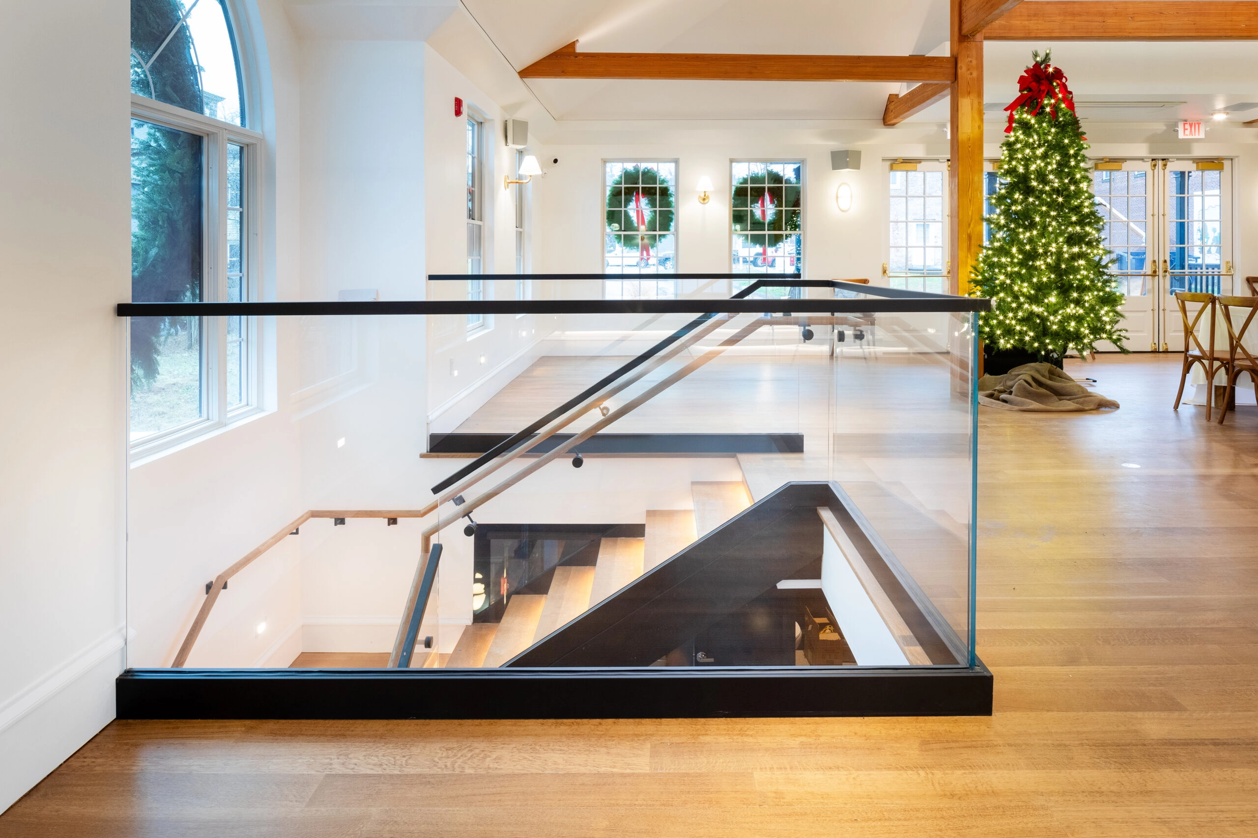 Glass balustrade set in a black base shoe around a stairwell opening