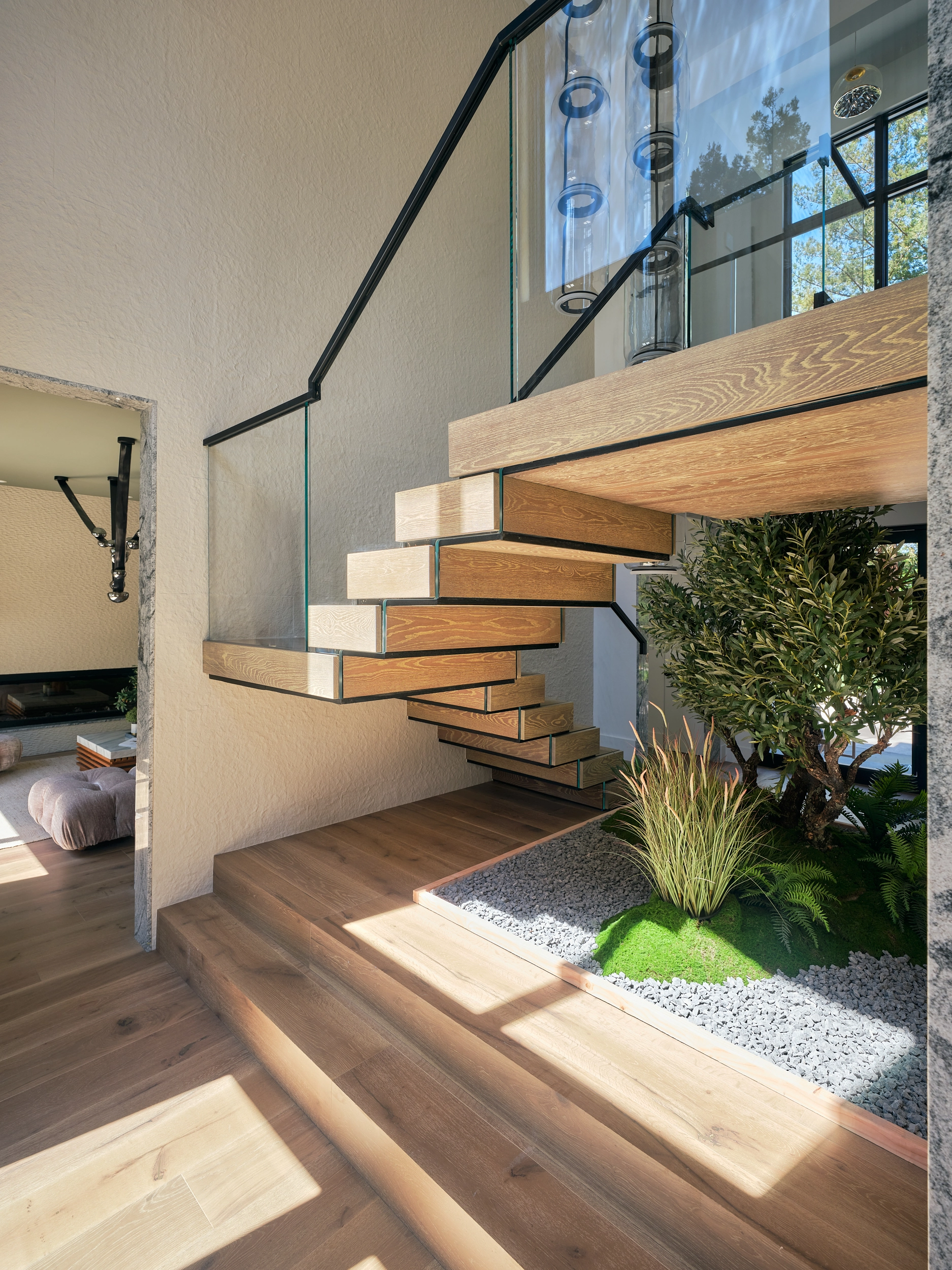 Stair from the side showing open risers, grasses and gravel bed, warm plank floor
