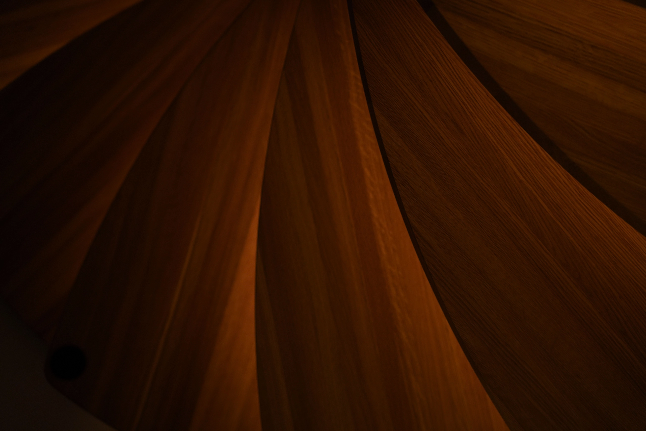 Warm-toned tread undersides sweeping through shadow in a tight abstract detail