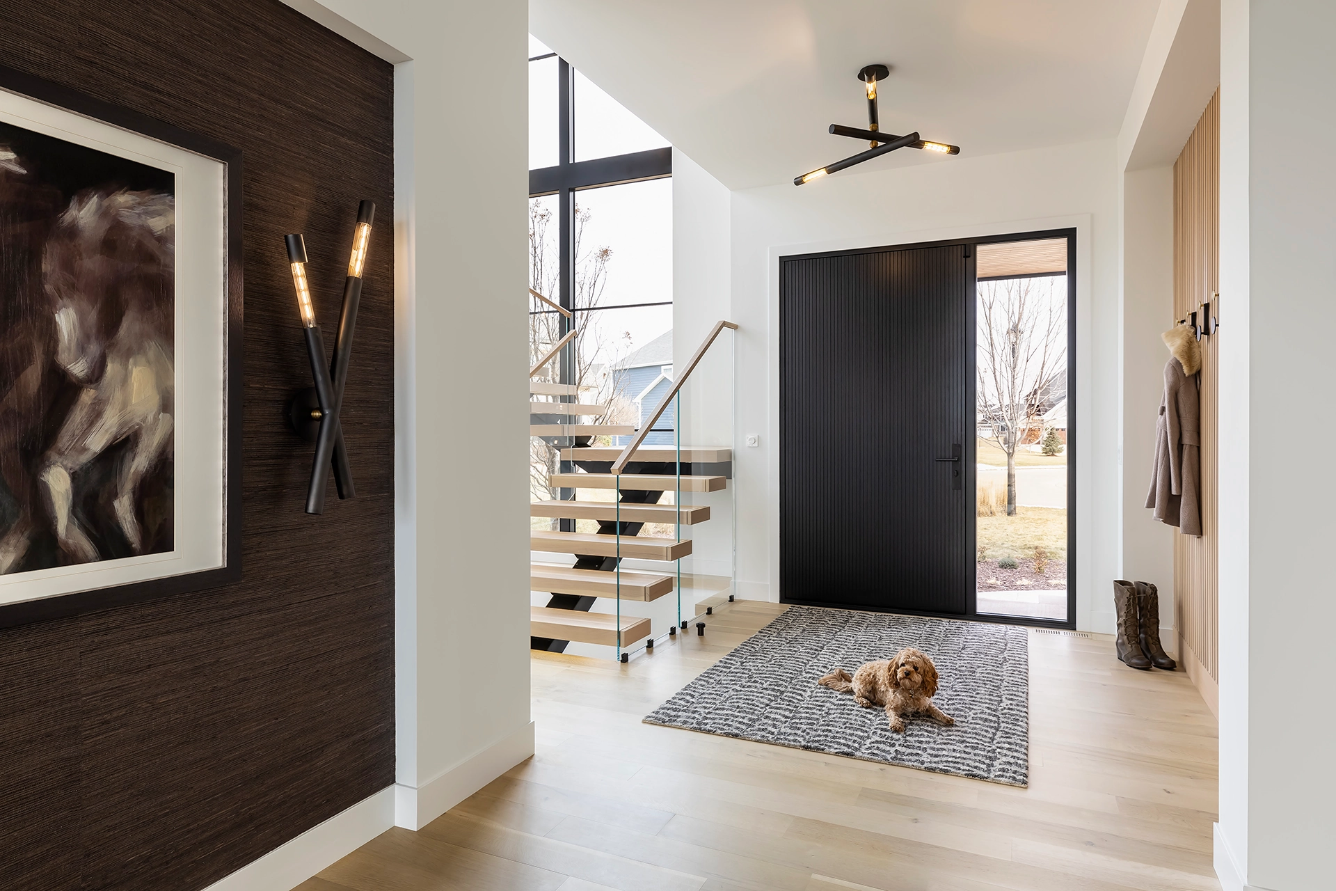 Foyer with a dark front door and the flight visible past the wall