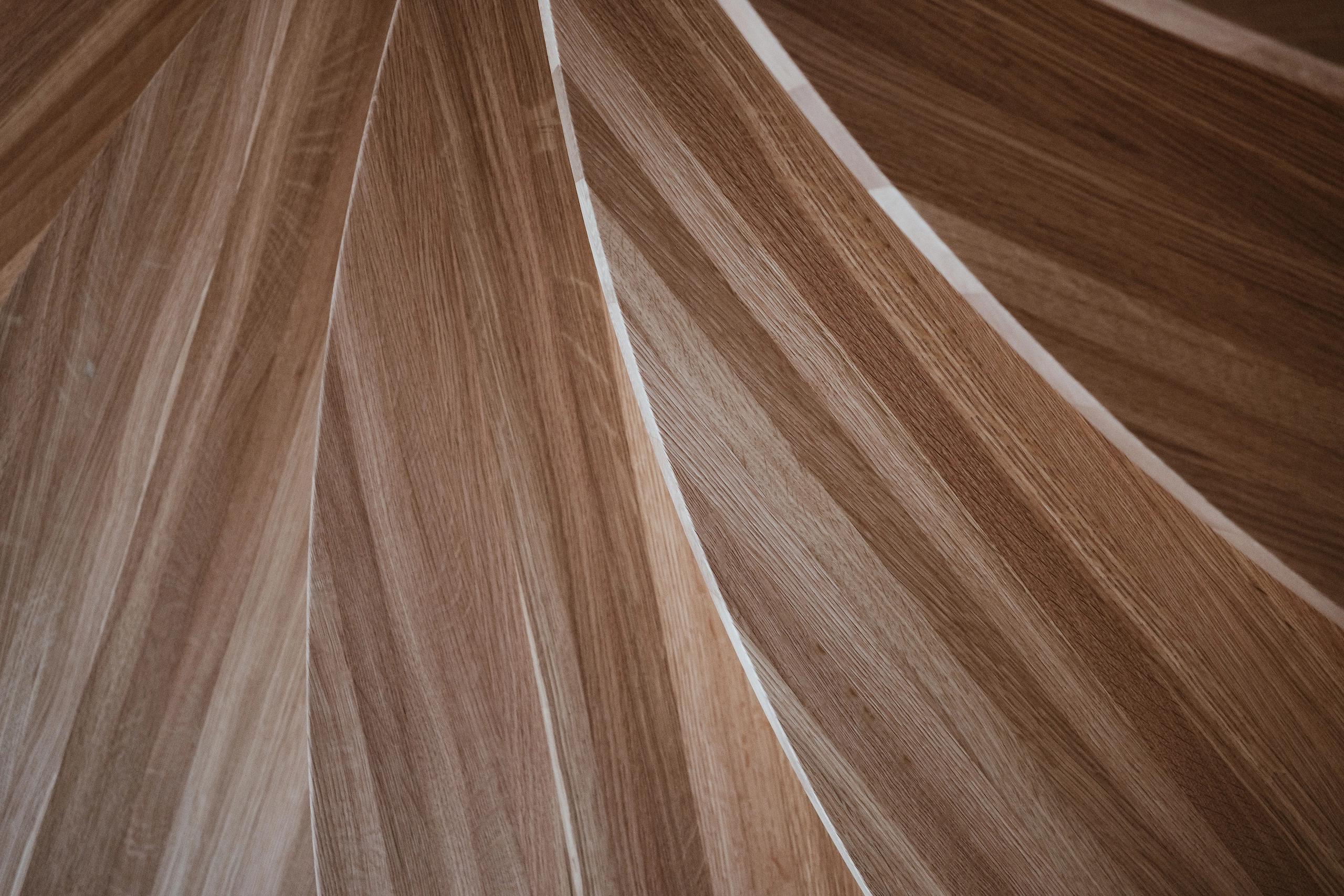 Tight detail of tread undersides fanning outward in pale striped wood