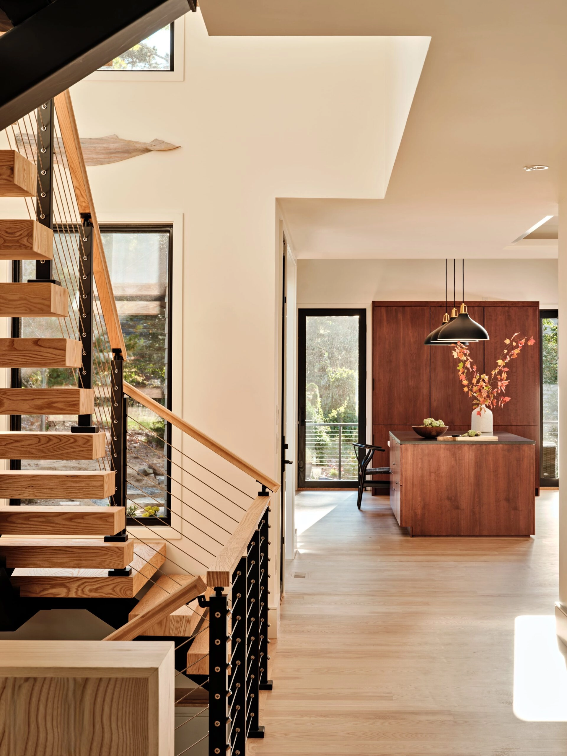 View past the flight toward a kitchen island in warm stained wood