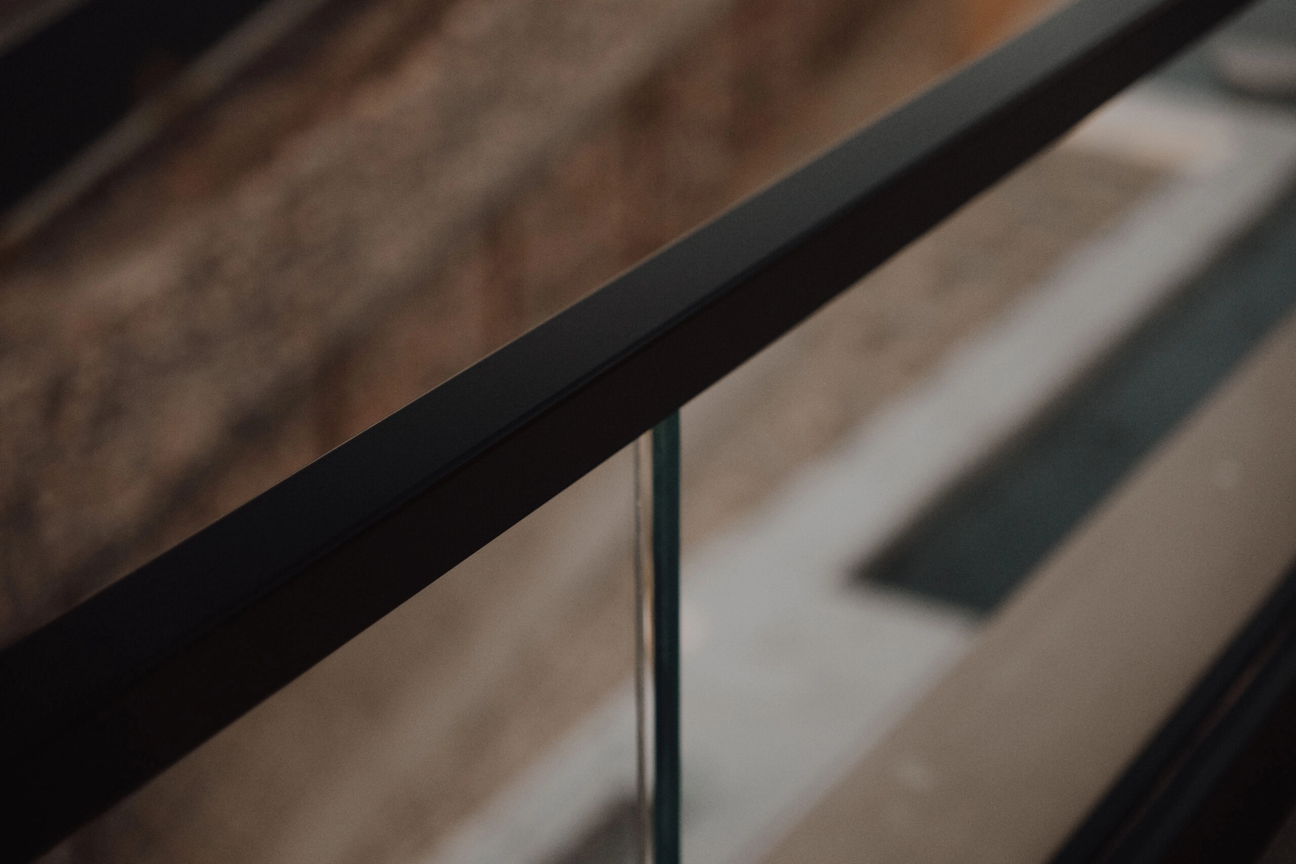 Close view of the dark top rail capping a clear glass panel