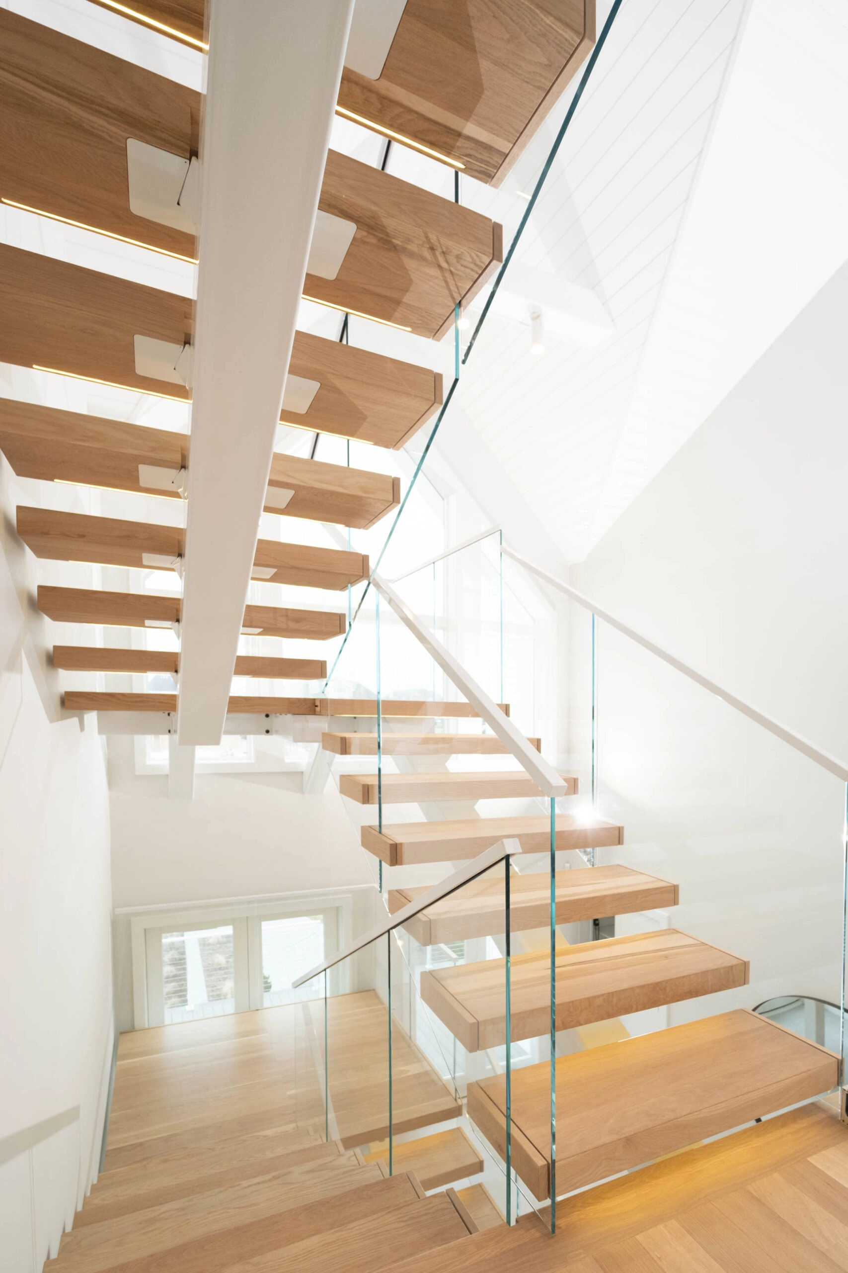 View up the stairwell with treads overhead and plank flooring far below