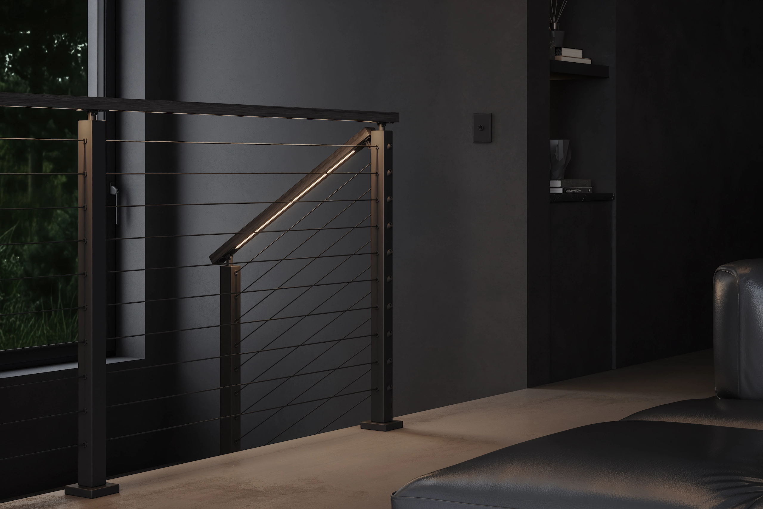 Cable run ending at a newel with a lit handrail against dark plaster
