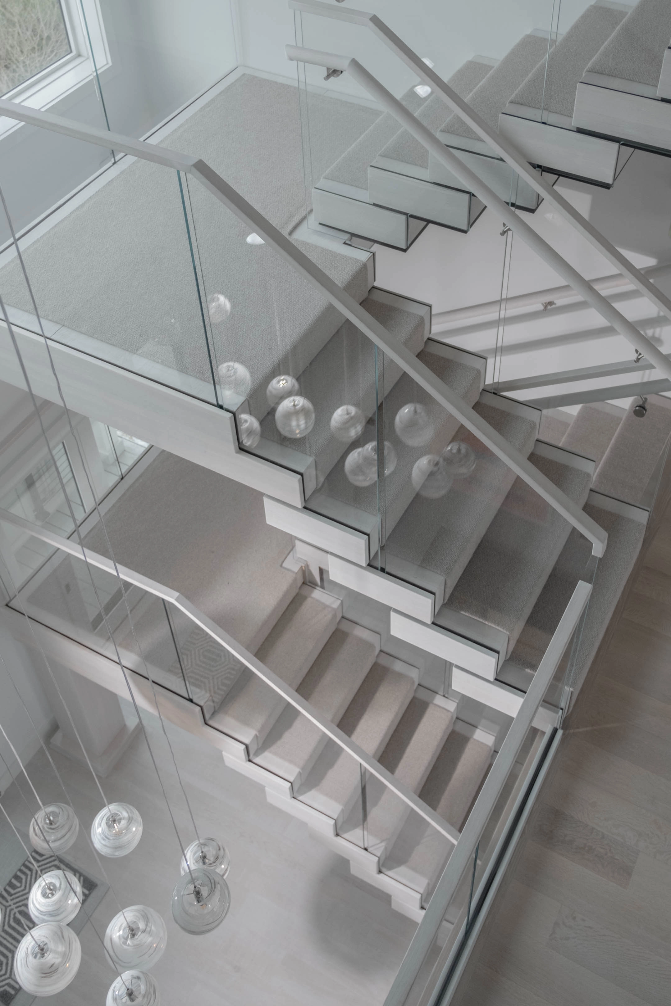 Looking down from above on stacked flights wrapped in glass railing