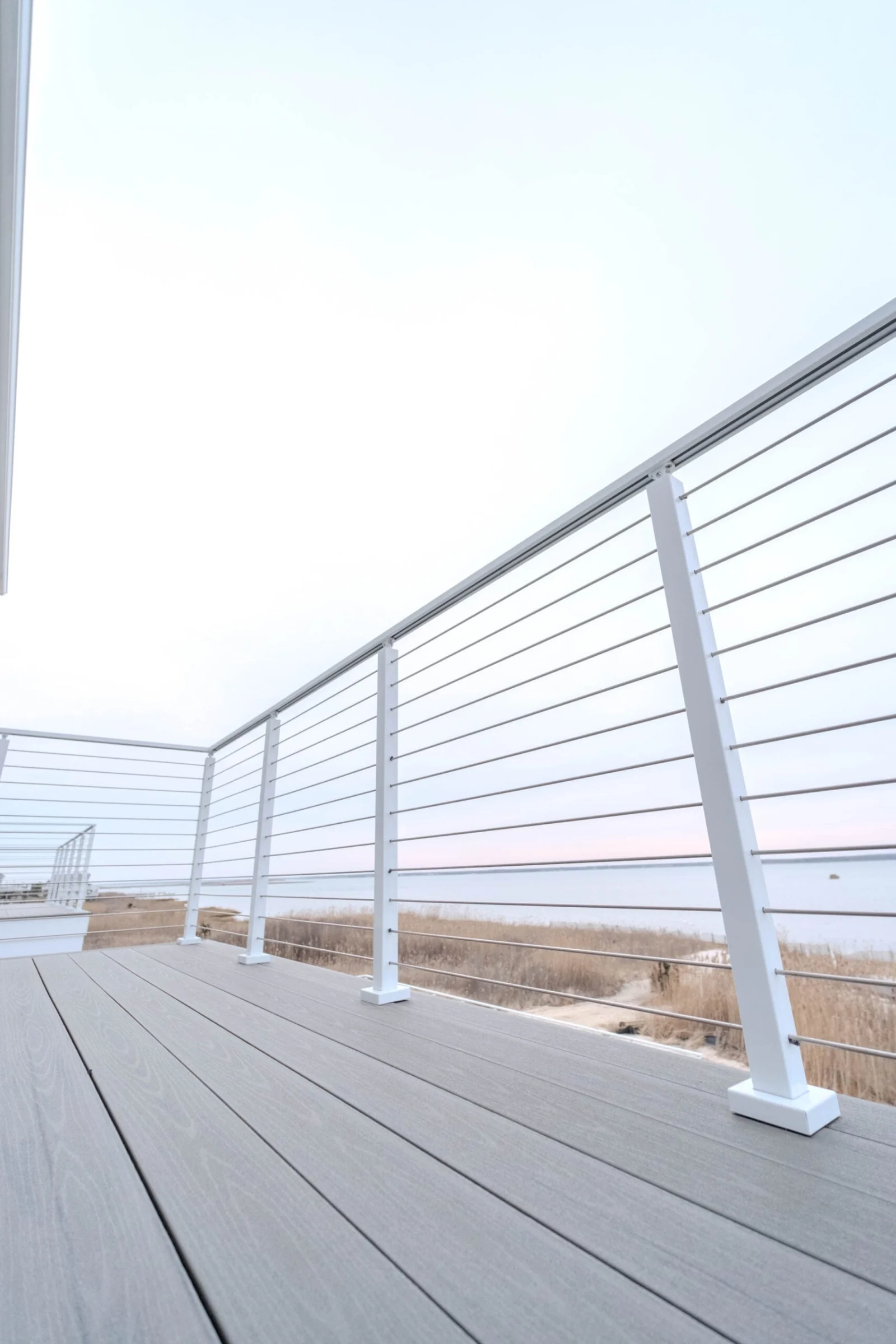 Looking down the deck with white railing running toward the waterline