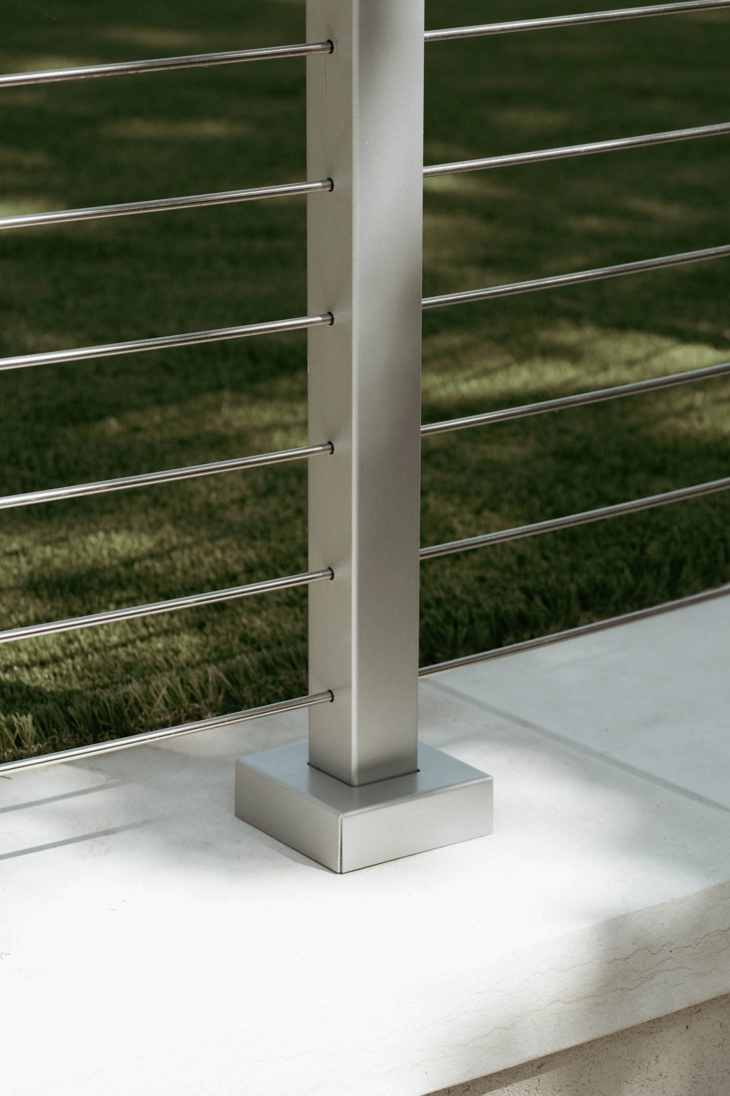 Brushed post and base plate anchored to a stone cap with rods behind