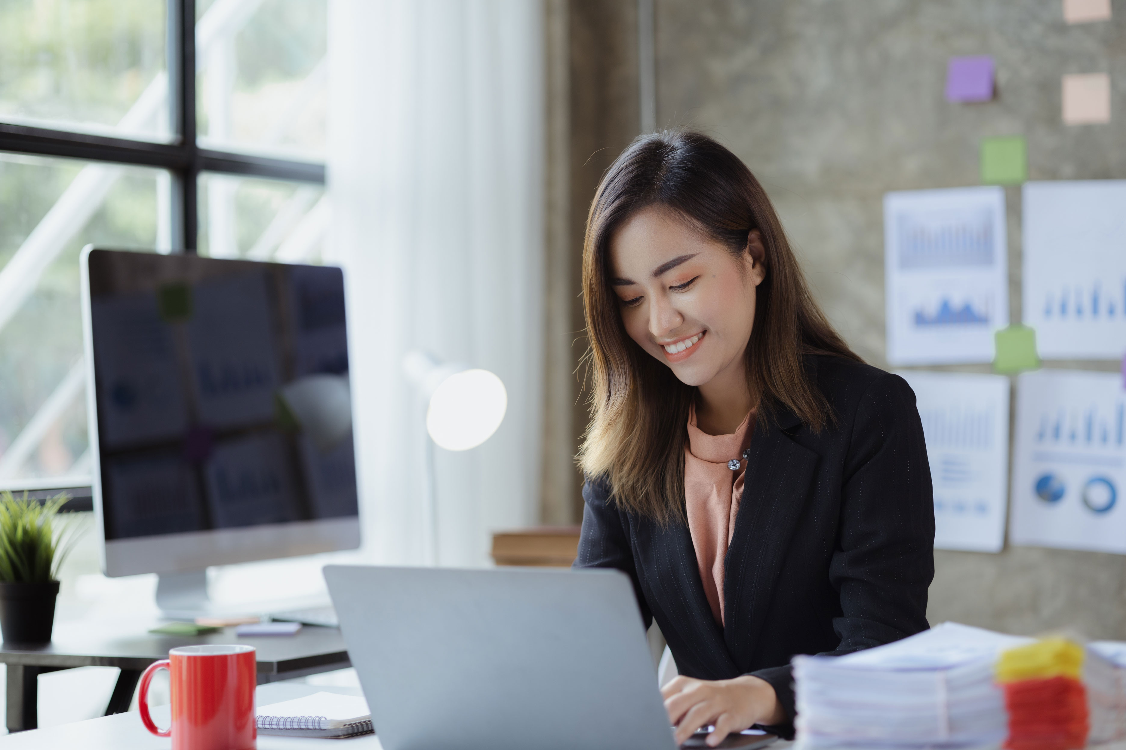 An established business operator at her laptop, reviewing her business finances on the Aion platform.