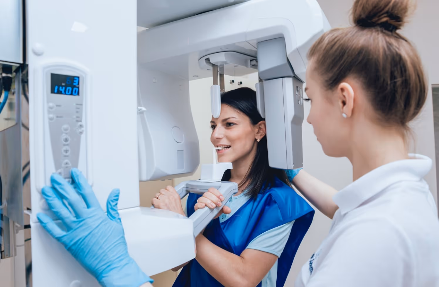 Dental assistant helping a patient during a panoramic X-ray scan