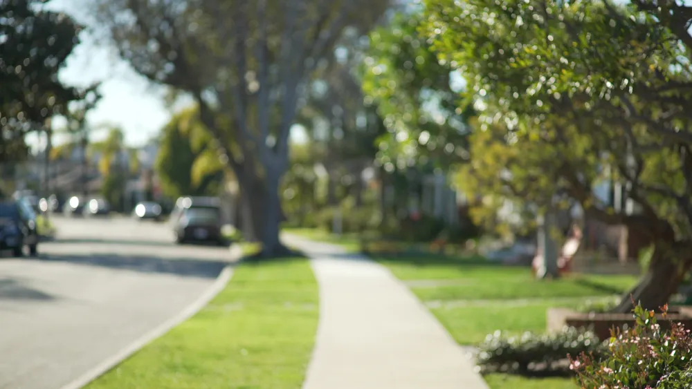 A sunny neighborhood in Oklahoma City, OK, featuring beautiful lawns maintained by lawn care companies that provide lawn care services and lawn maintenance.