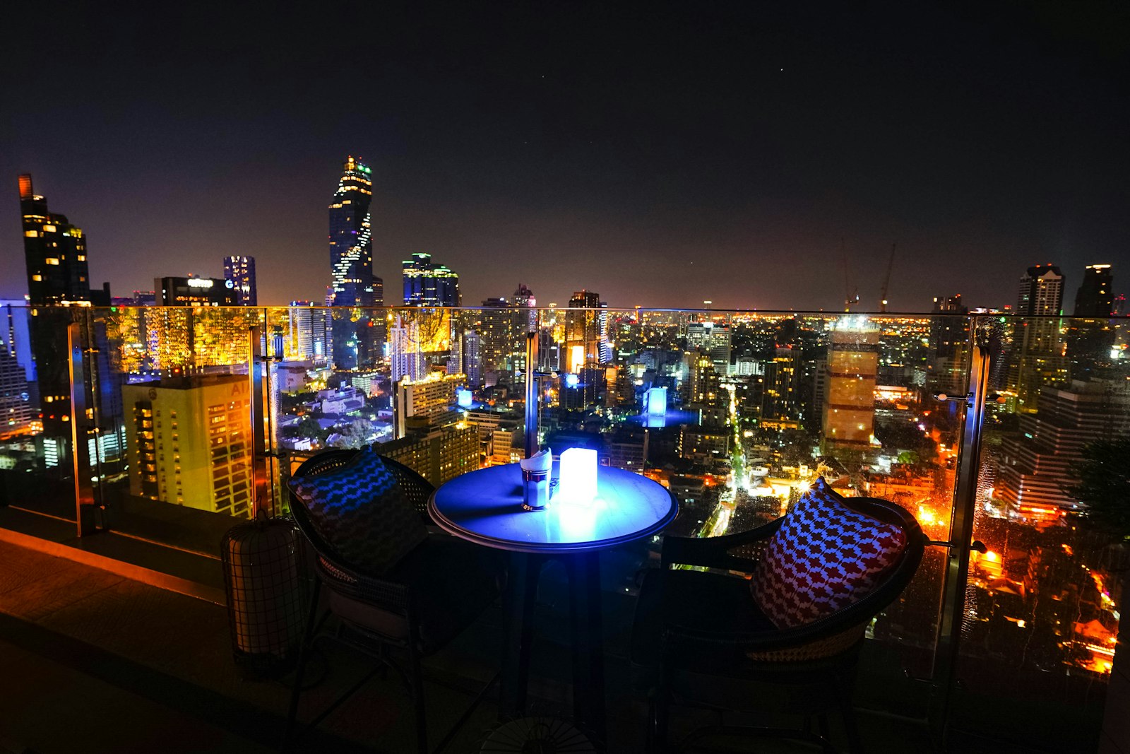 Rooftop balcony overlooking a city skyline at night