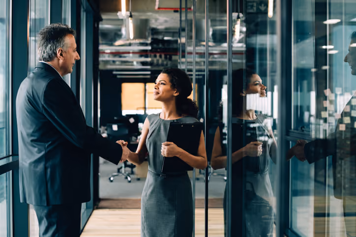 Employee shaking hands with their boss at a new job transfer.