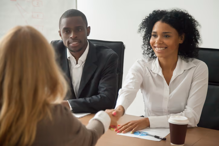 Woman shaking hands with her new boss after a job transfer.