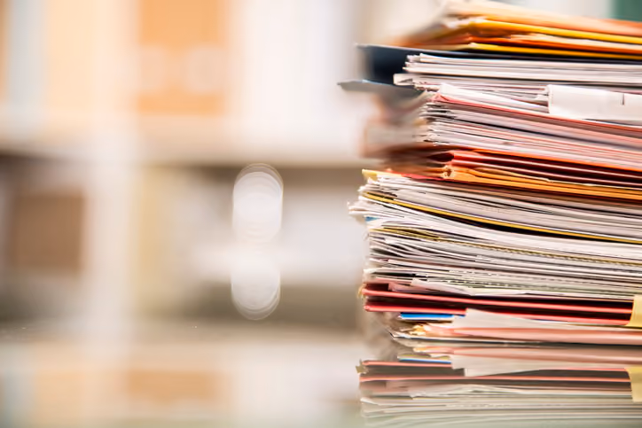 A stack of paperwork needed to sell a house by owner.