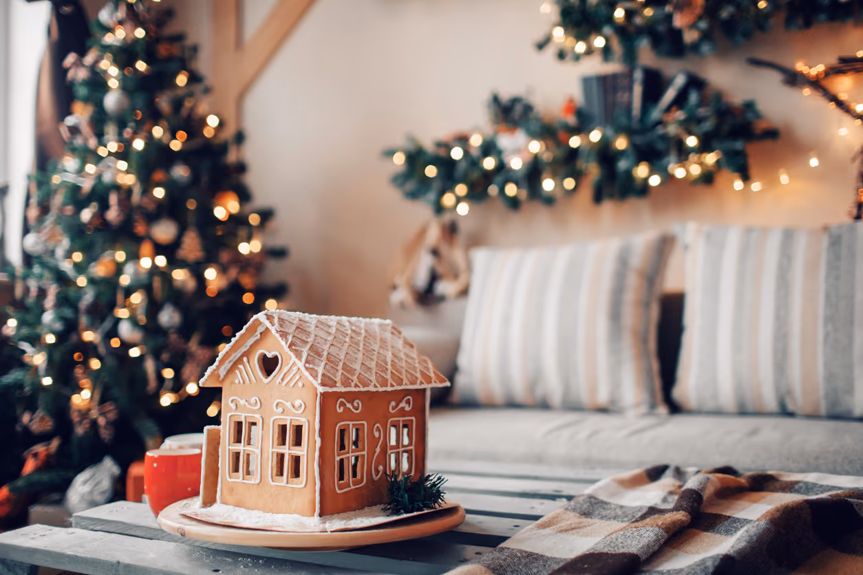 Homemade gingerbread house on light room background to sell a house during the holidays.