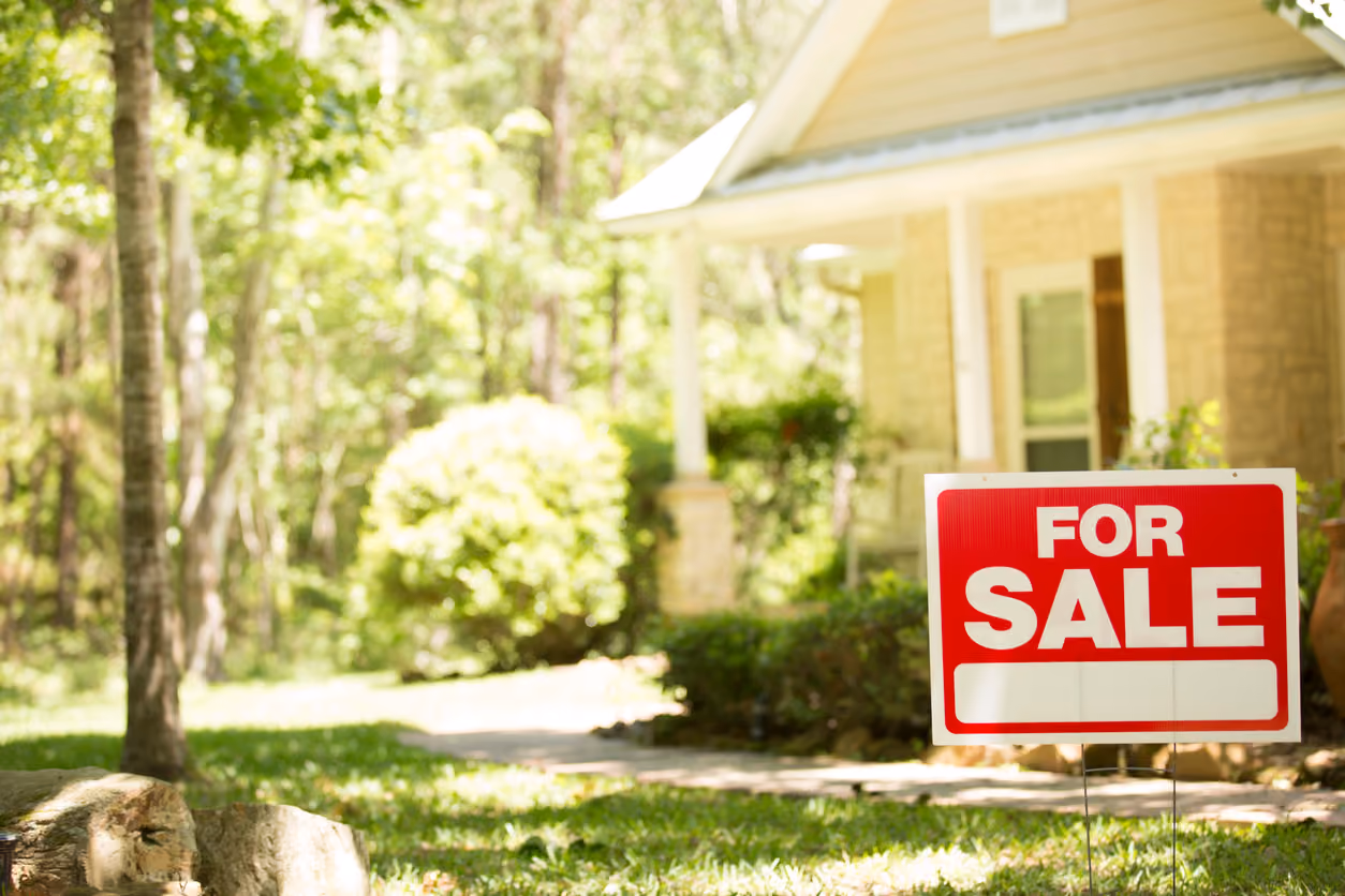Home for sale on Craigslist with real estate sign in spring or summer season.
