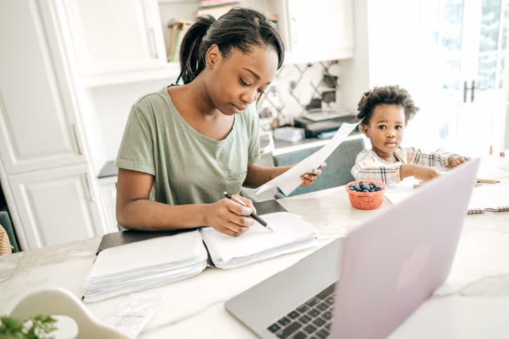 Mom working with her toddler and figuring out tax implications when selling a rental property.
