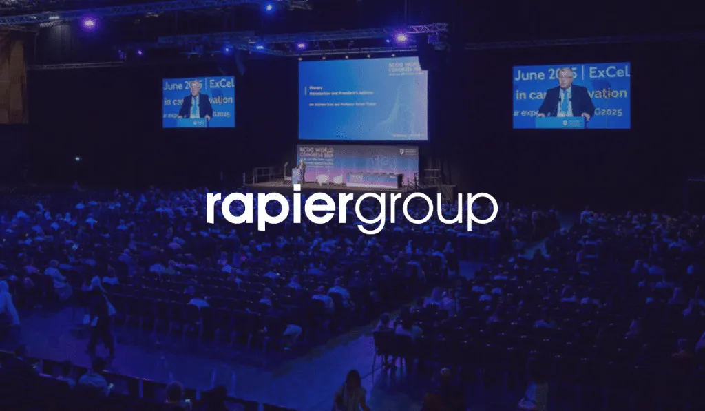 Rapiergroup logo over a large plenary hall at RCOG World Congress with delegates seated