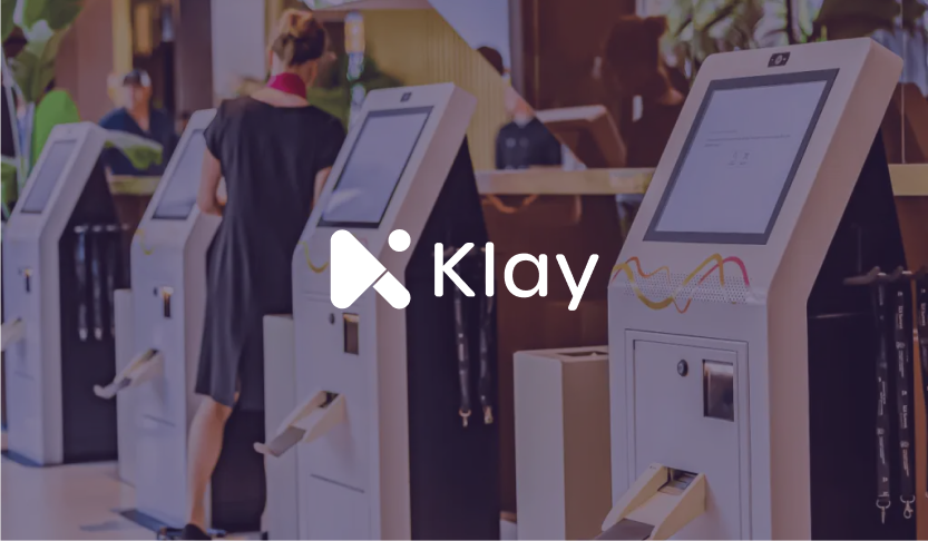 Klay logo over a row of self check-in kiosks with an attendee using one
