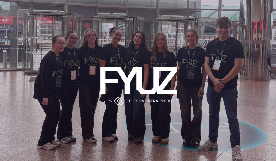 FYUZ by Telecom Infra Project logo over the event crew in branded shirts at a venue entrance